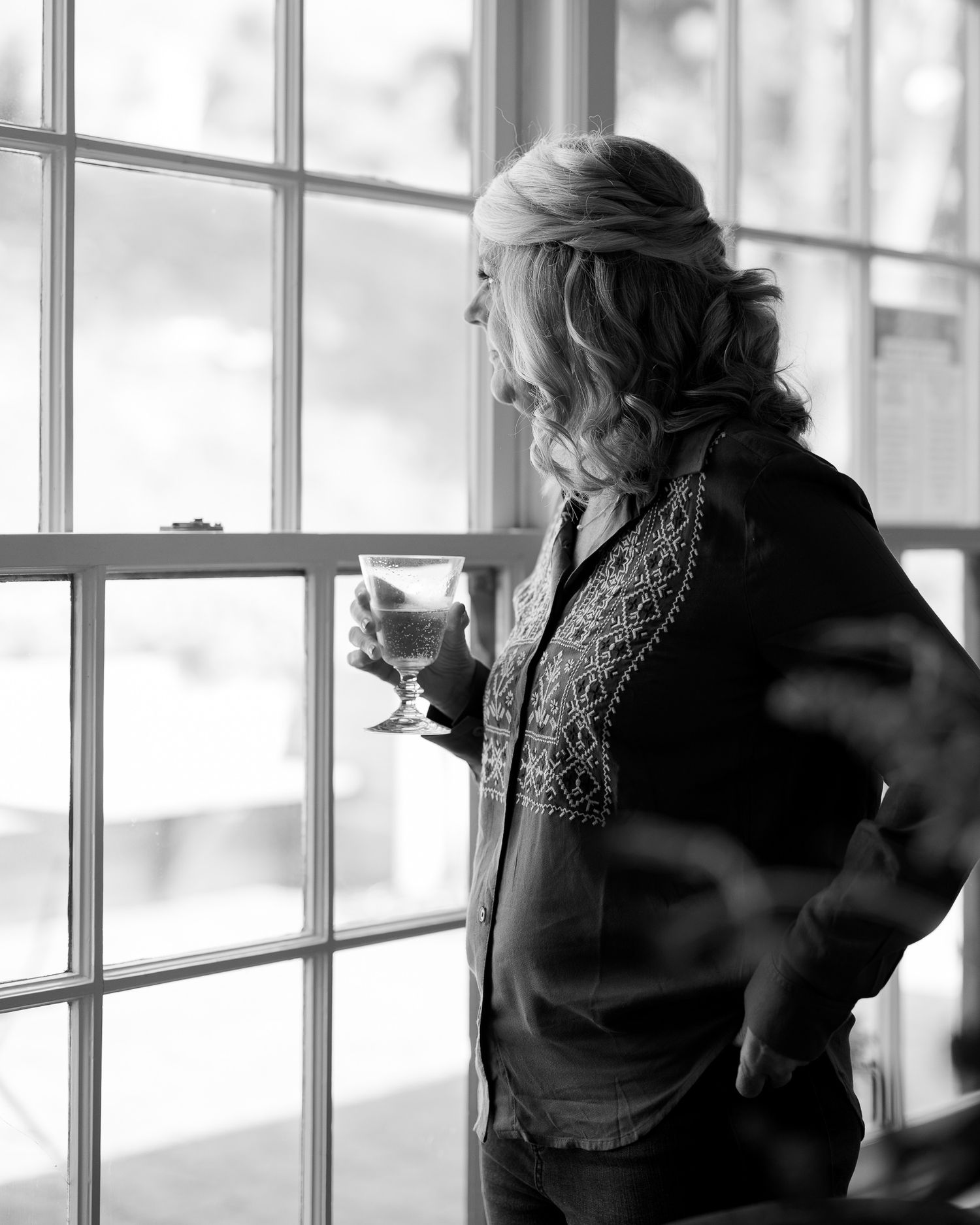 Emotional black and white of a guest by the window at a Cuffey's Cove wedding in Elk, Mendocino, by Sammy Aucella Photography