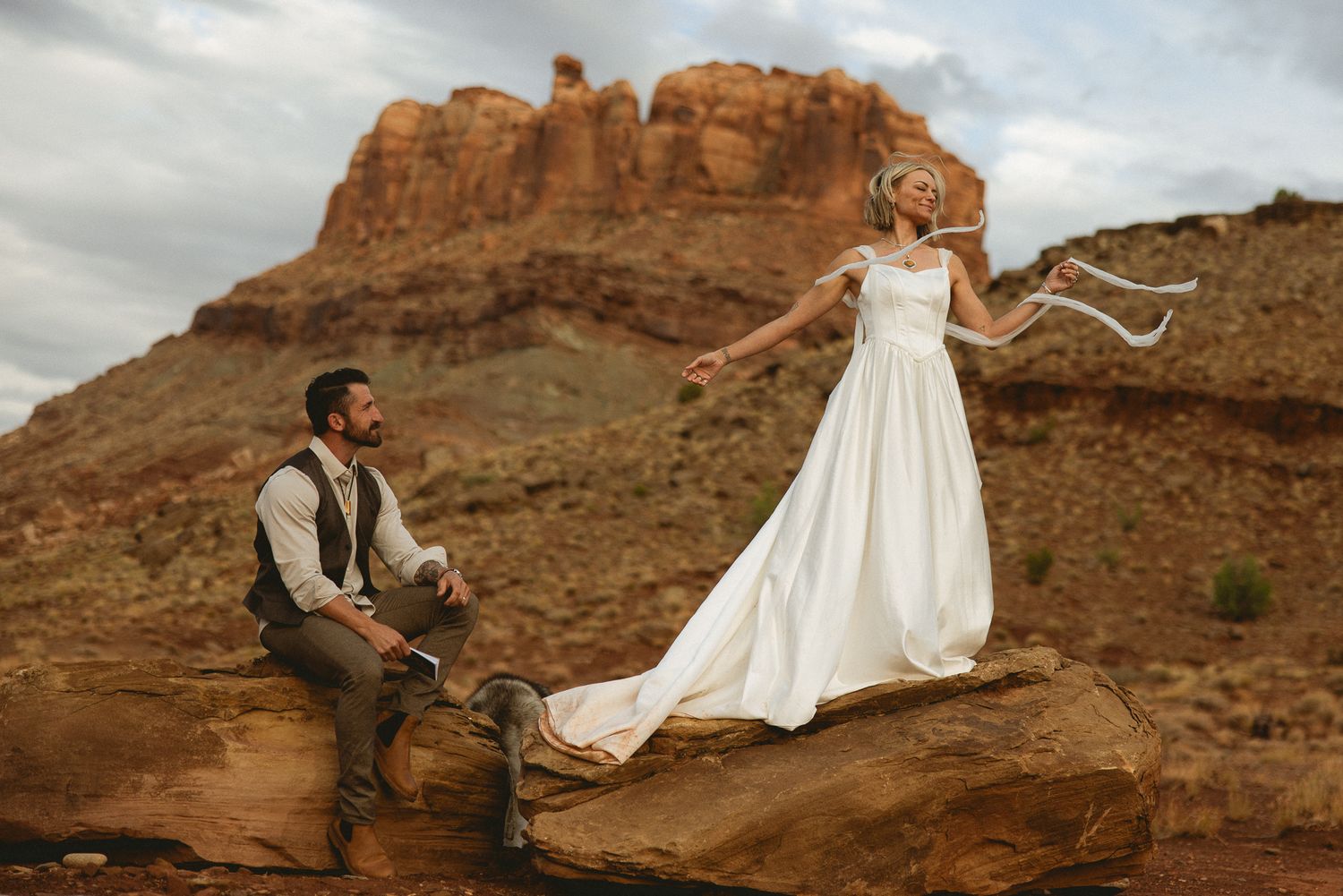 Bride on a Moab red rock formation with her groom in Utah, by Sammy Aucella Photography