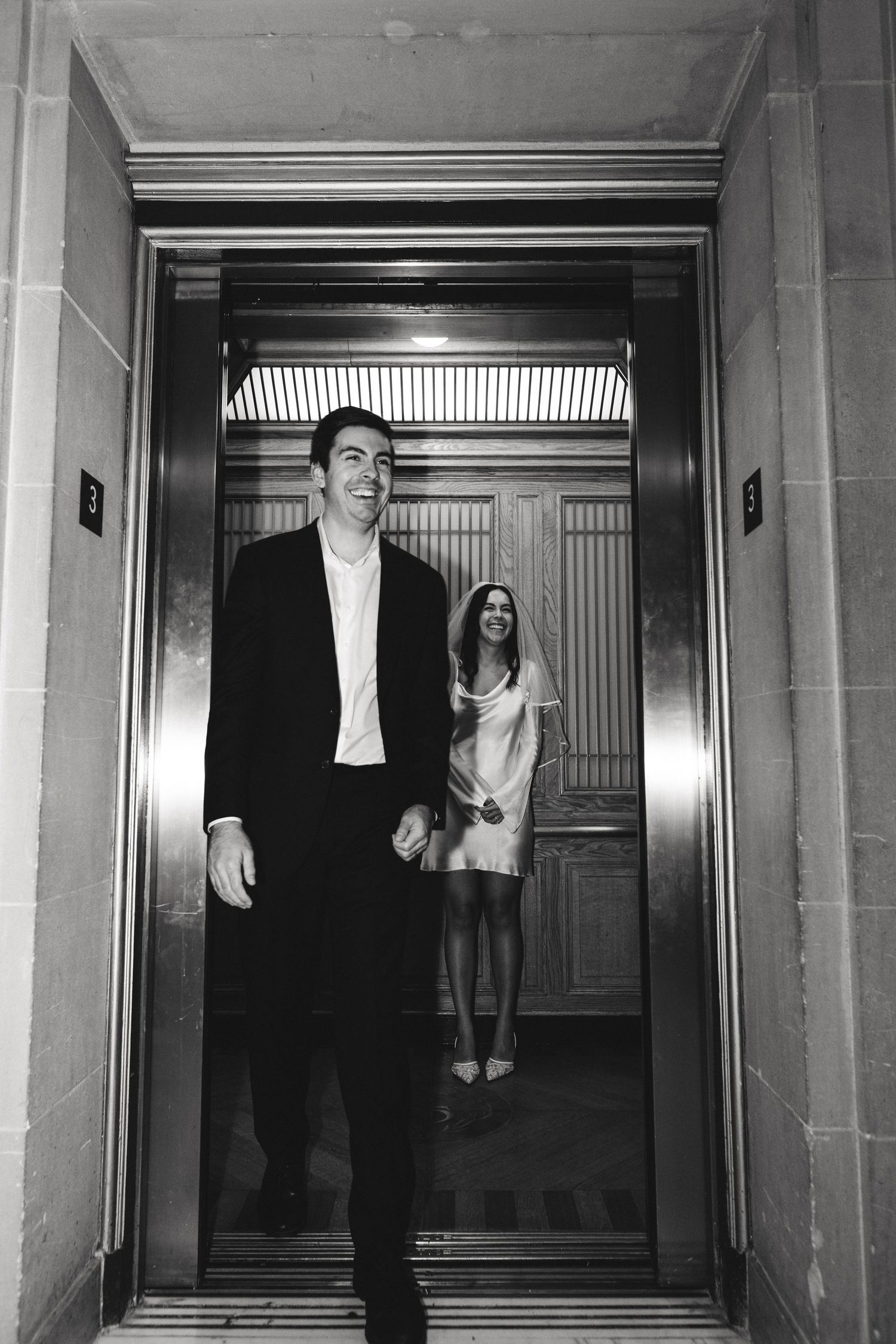 Black and white of the couple by the elevator at a San Francisco City Hall elopement, by Sammy Aucella Photography