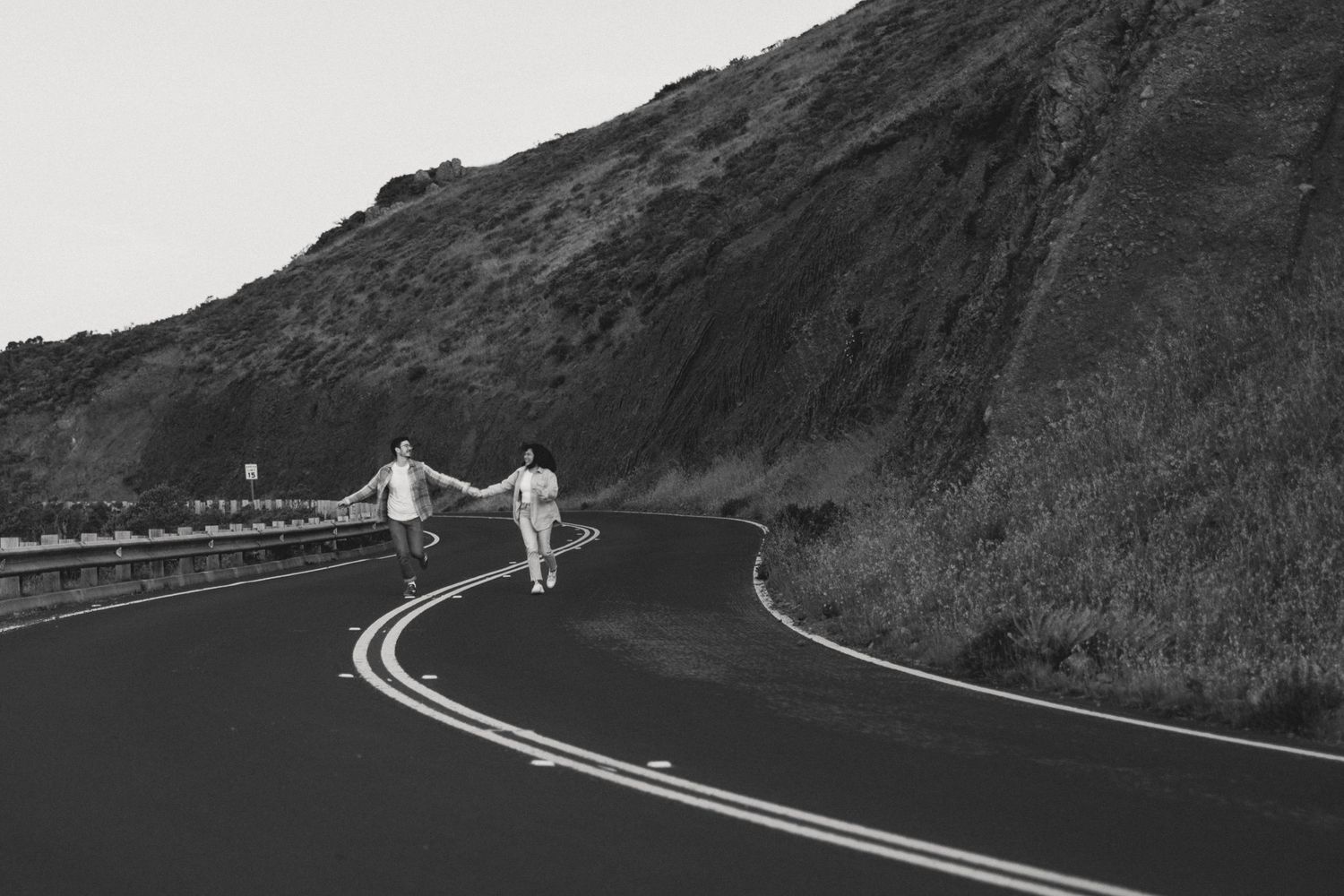 Couple running in Marin foothills near Golden Gate Bride San Francisco cinematic b&w engagement session by Sammy Aucella Photography