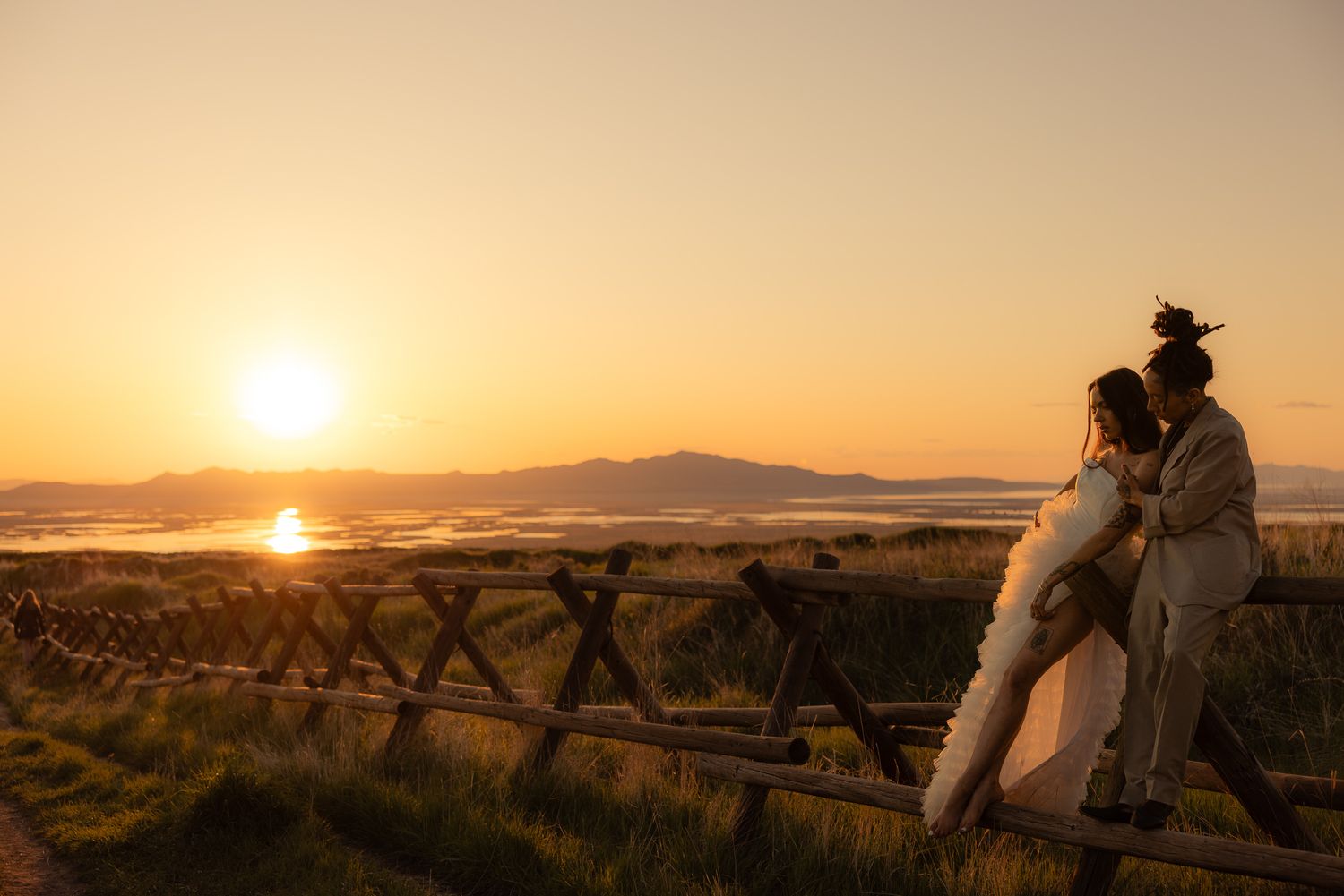 Cowboy groom and bride silhouetted at a desert sunset, by Sammy Aucella Photography