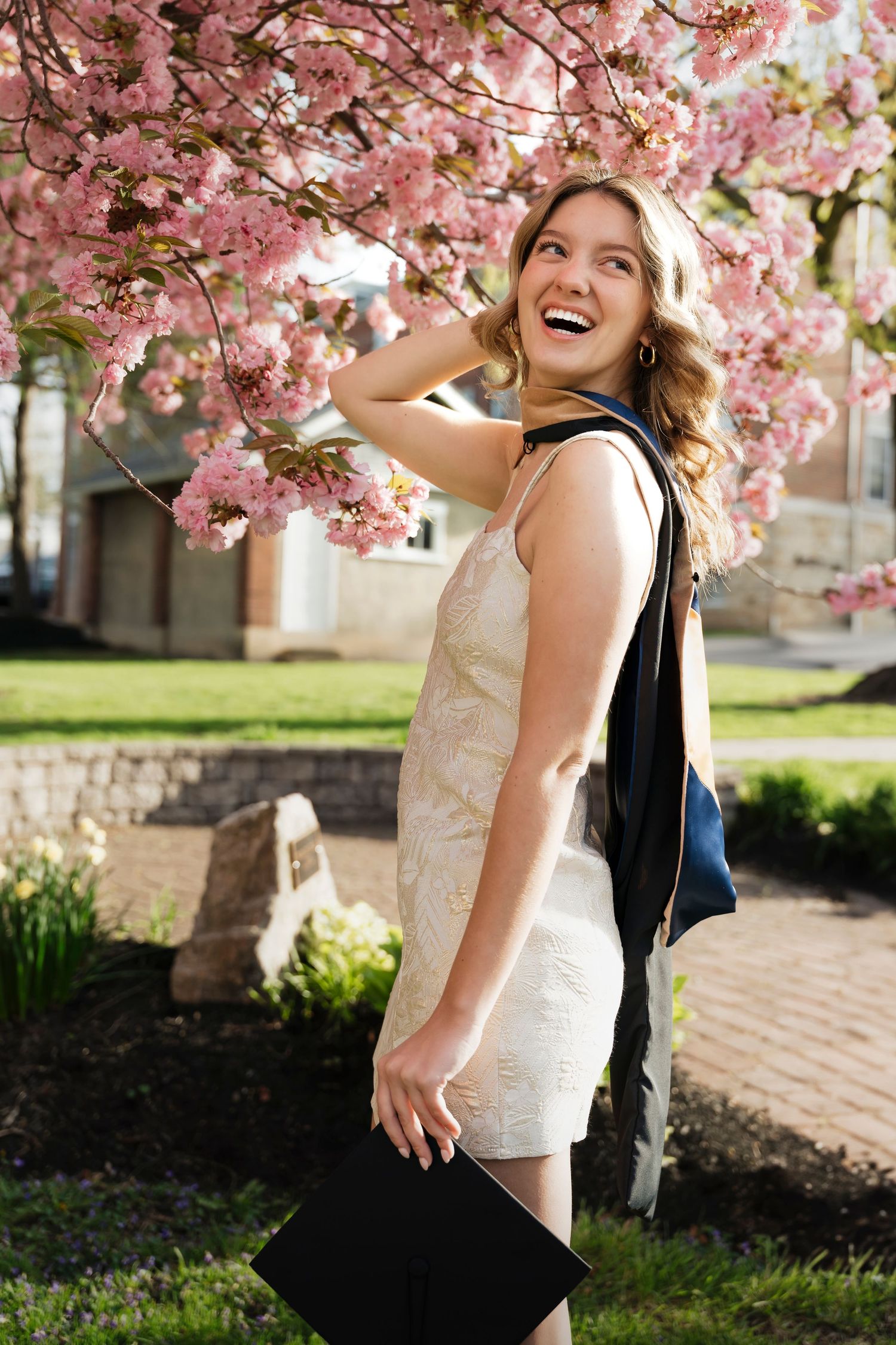 A joyful moment captured under blooming pink cherry blossoms in springtime.