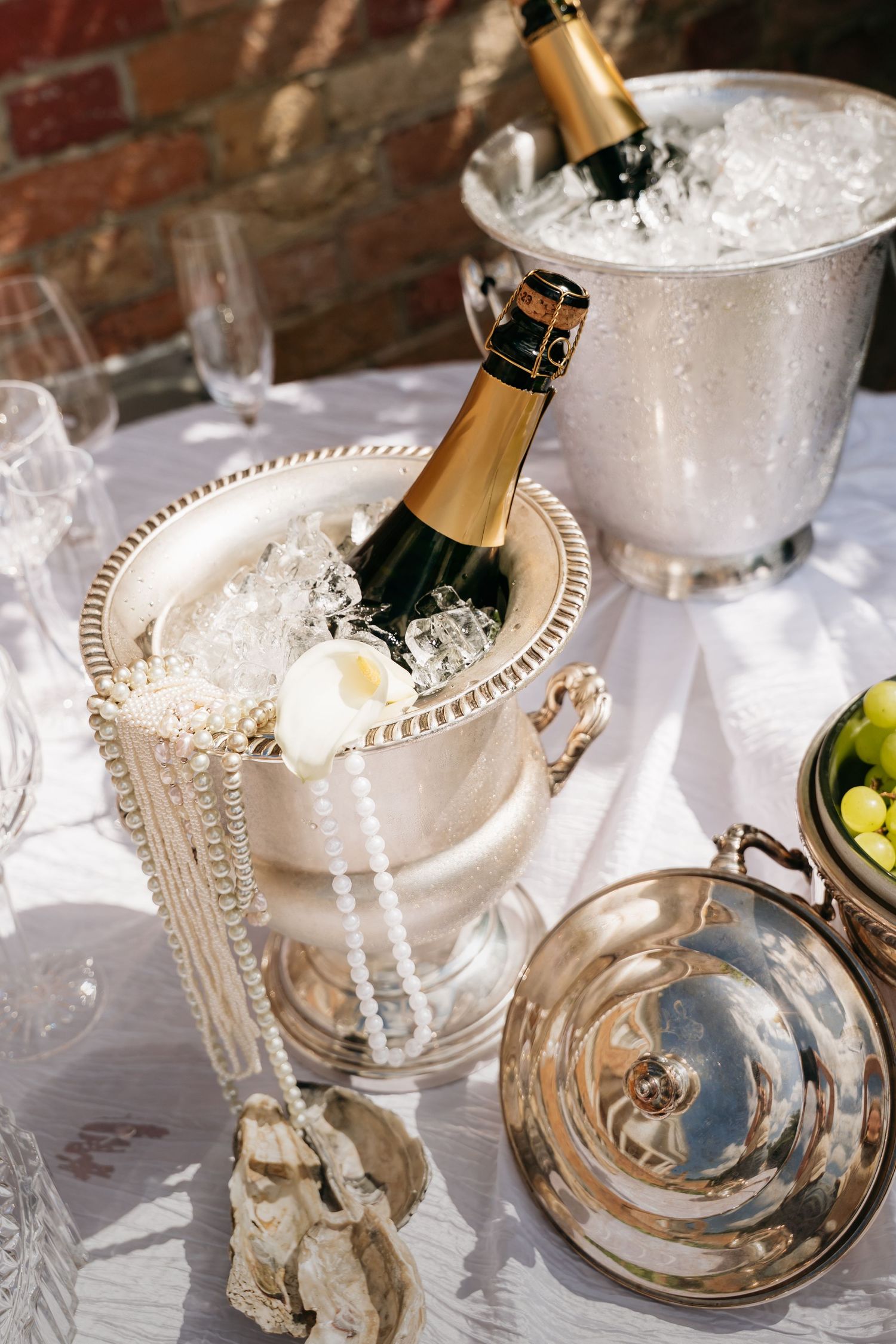Champagne bottles chilling in elegant pearl-trimmed ice buckets at an upscale event.