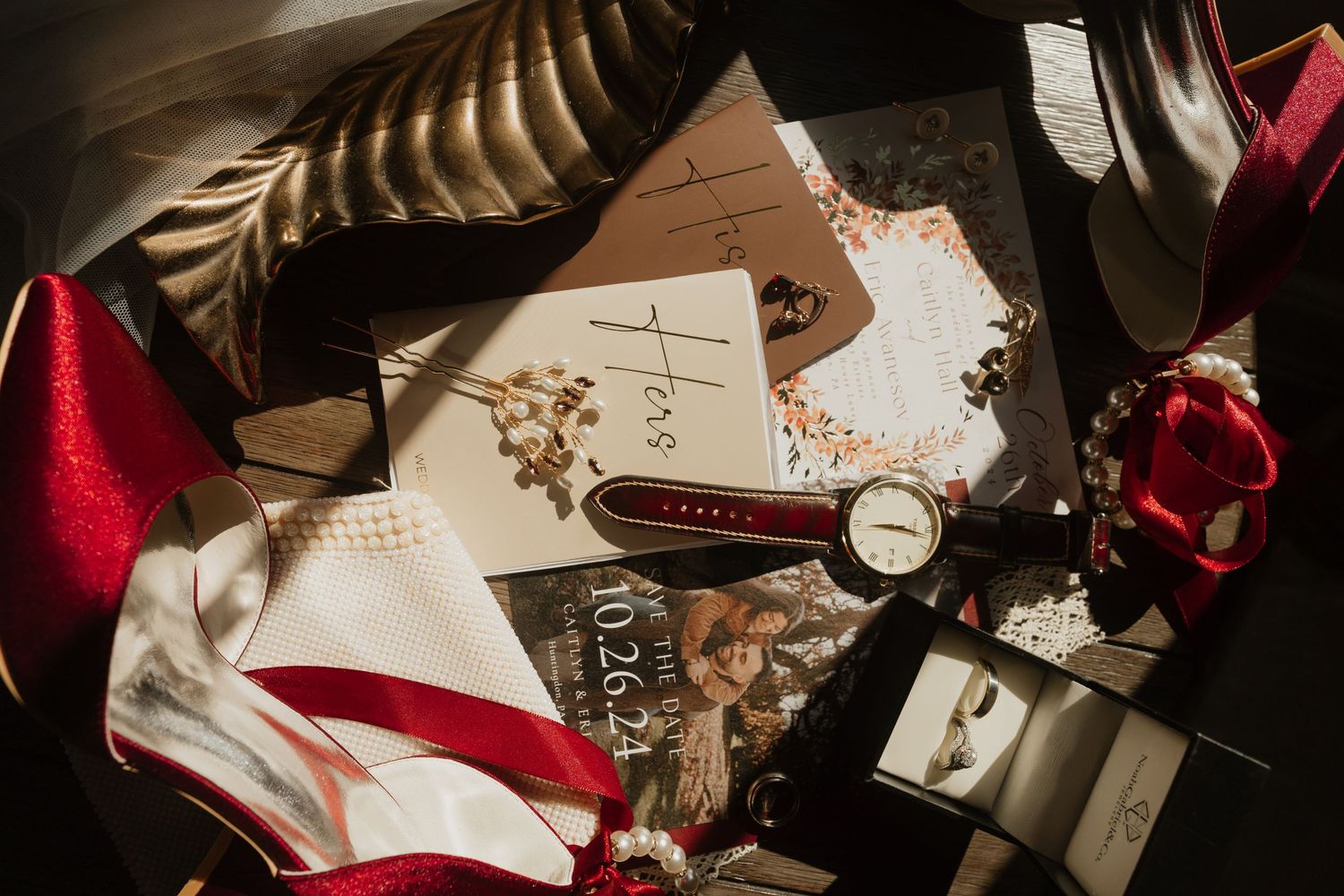 Wedding details and accessories arranged artistically on dark surface with vintage styling.