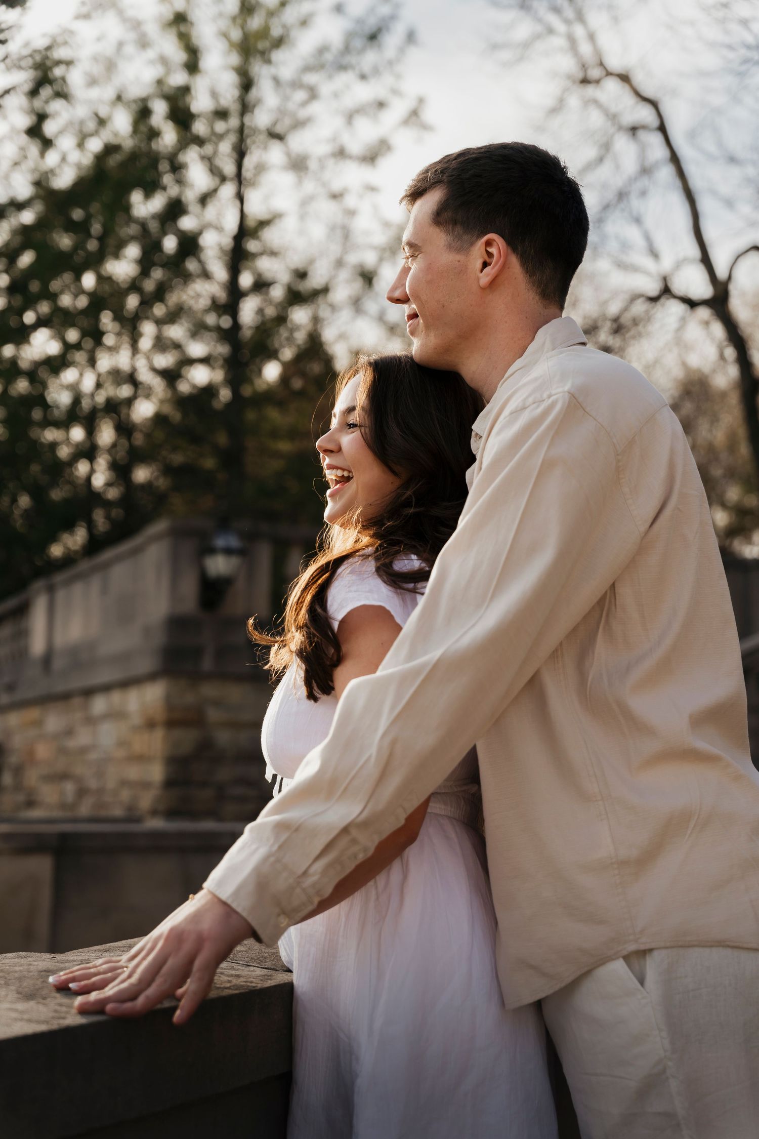 Elegant engagement portrait of couple in white outfits against 106-year-old estate architecture in Loretto PA
