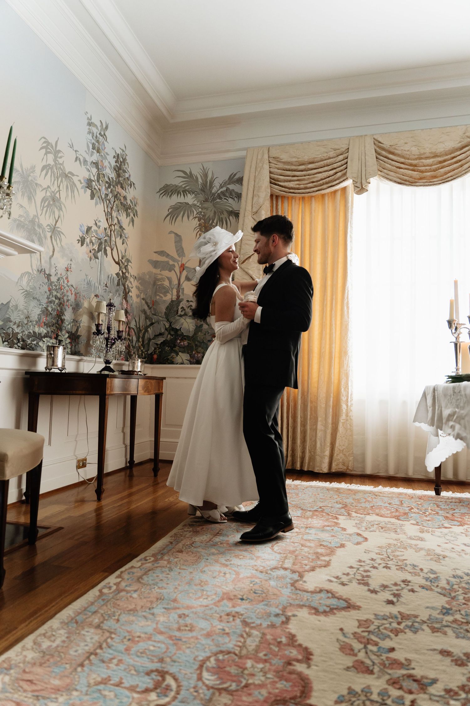 A sequence of wedding dance photos showing a couple performing a romantic first dance in an elegant room with floral wallpaper.