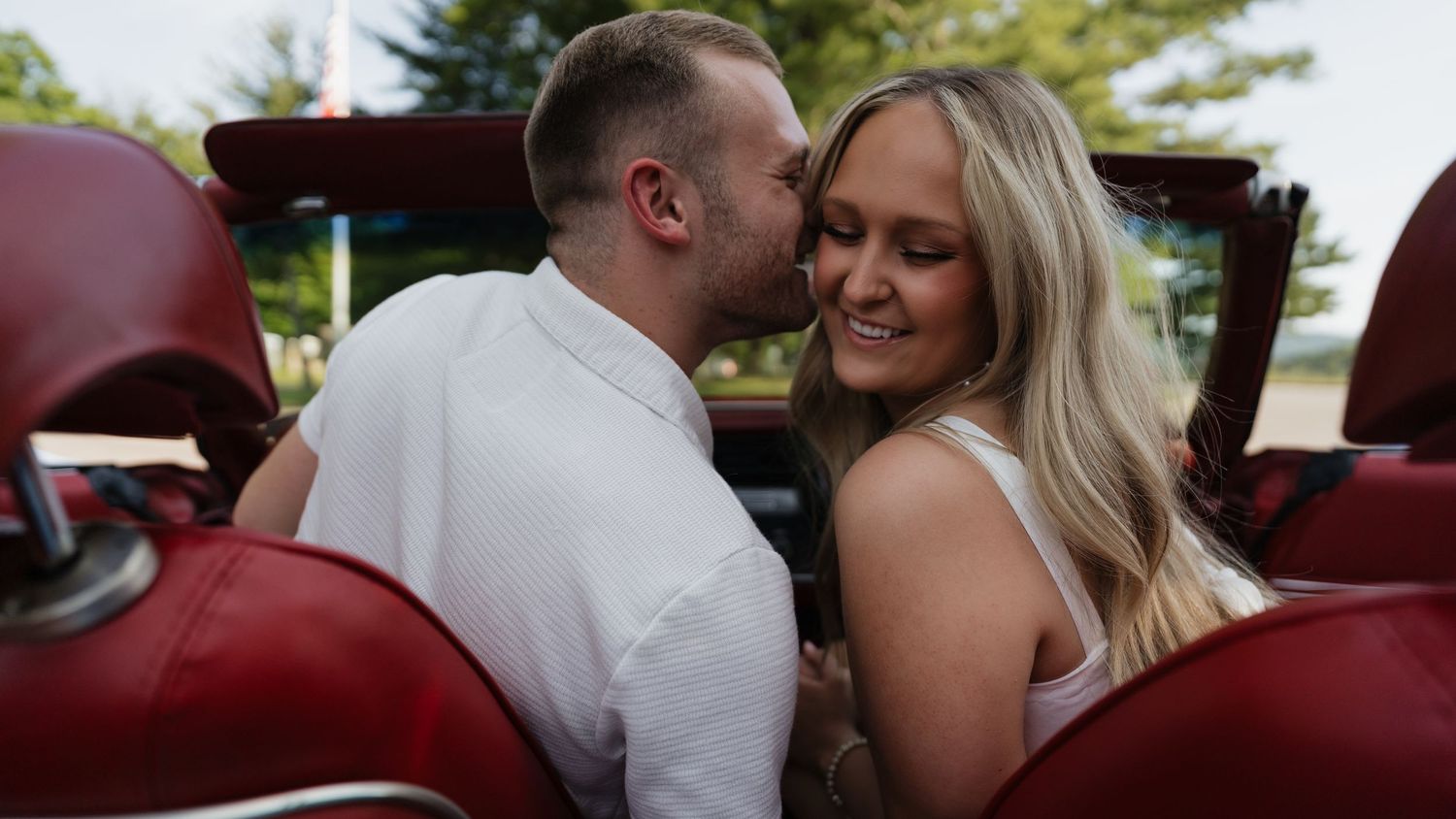A romantic vintage car photoshoot with a classic red interior.