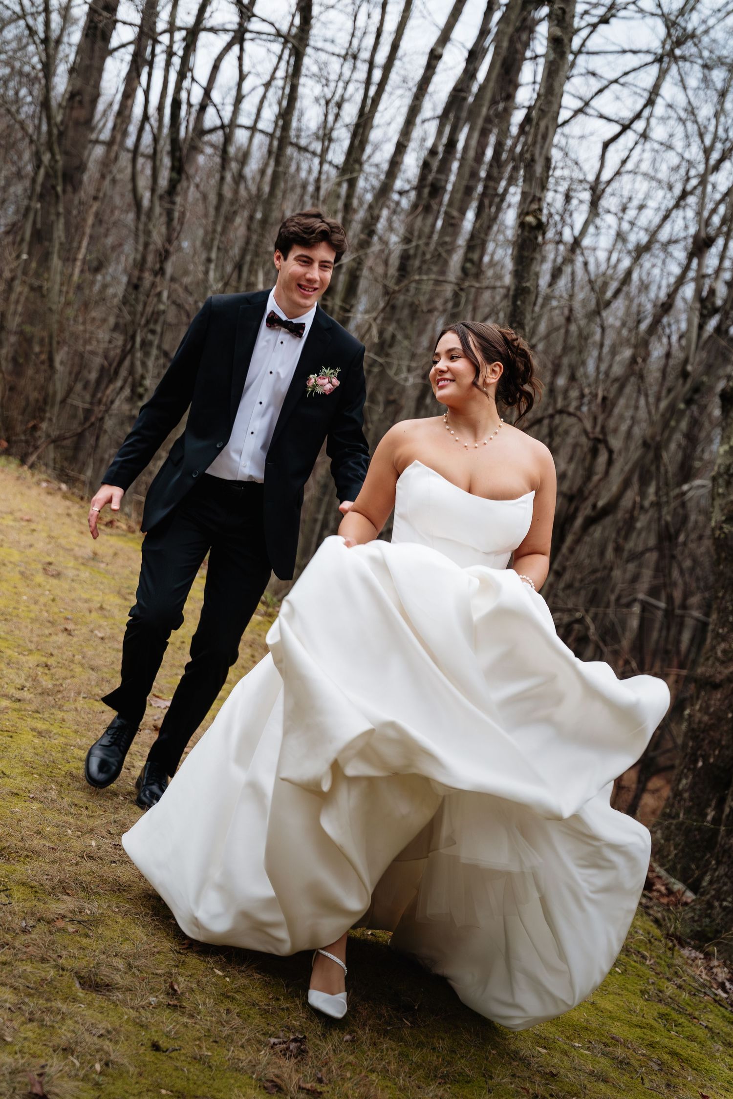 A romantic sequence of a couple in wedding attire playfully running and twirling through a wooded forest setting.