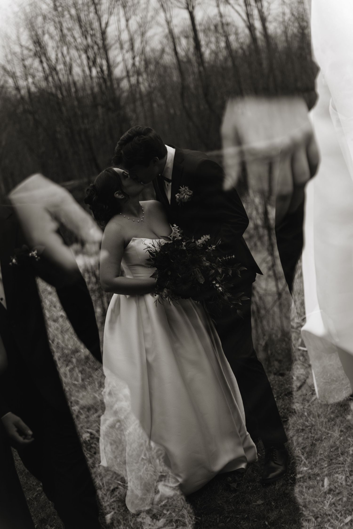 A series of blurred black and white photos showing ethereal figures moving through a misty wooded area.