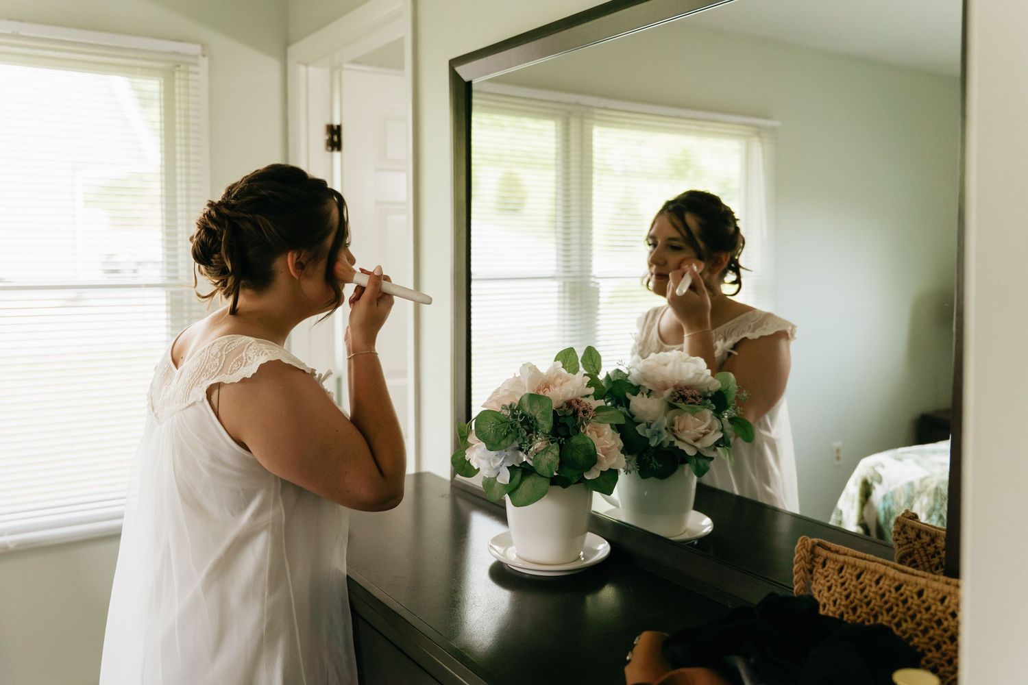 A sequence of black and white wedding preparation photos showing someone getting ready in an elegant room.