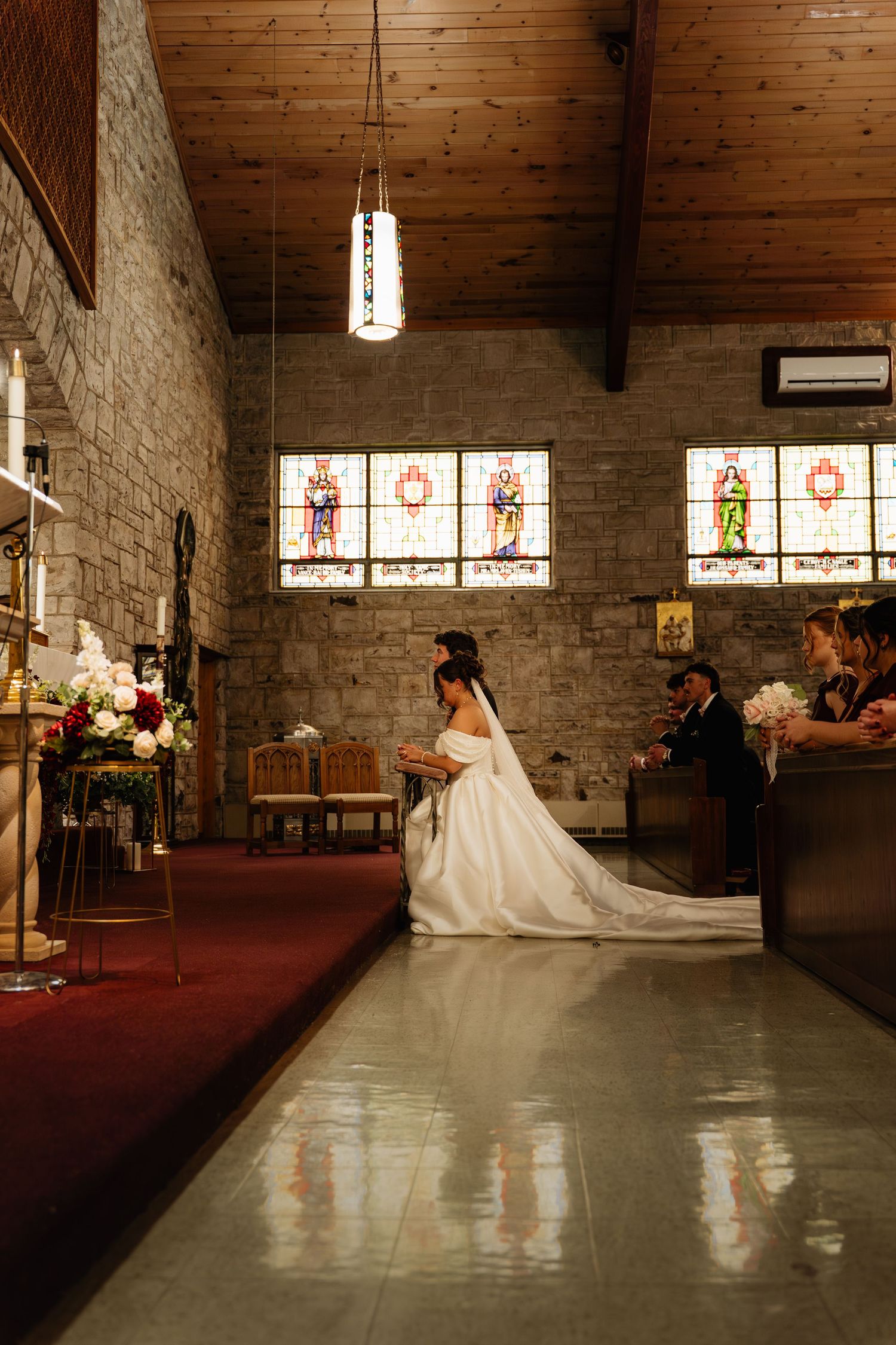 A sequence of six photos showing a bride in a white gown walking across a church sanctuary with stained glass windows.