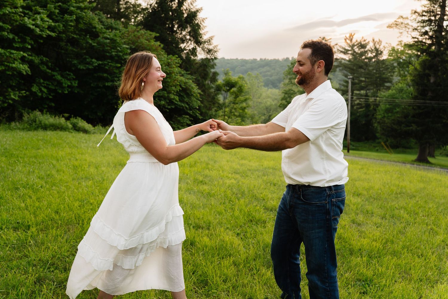 Couple in white and jeans dance together across five connected photos in a grassy outdoor field at sunset.