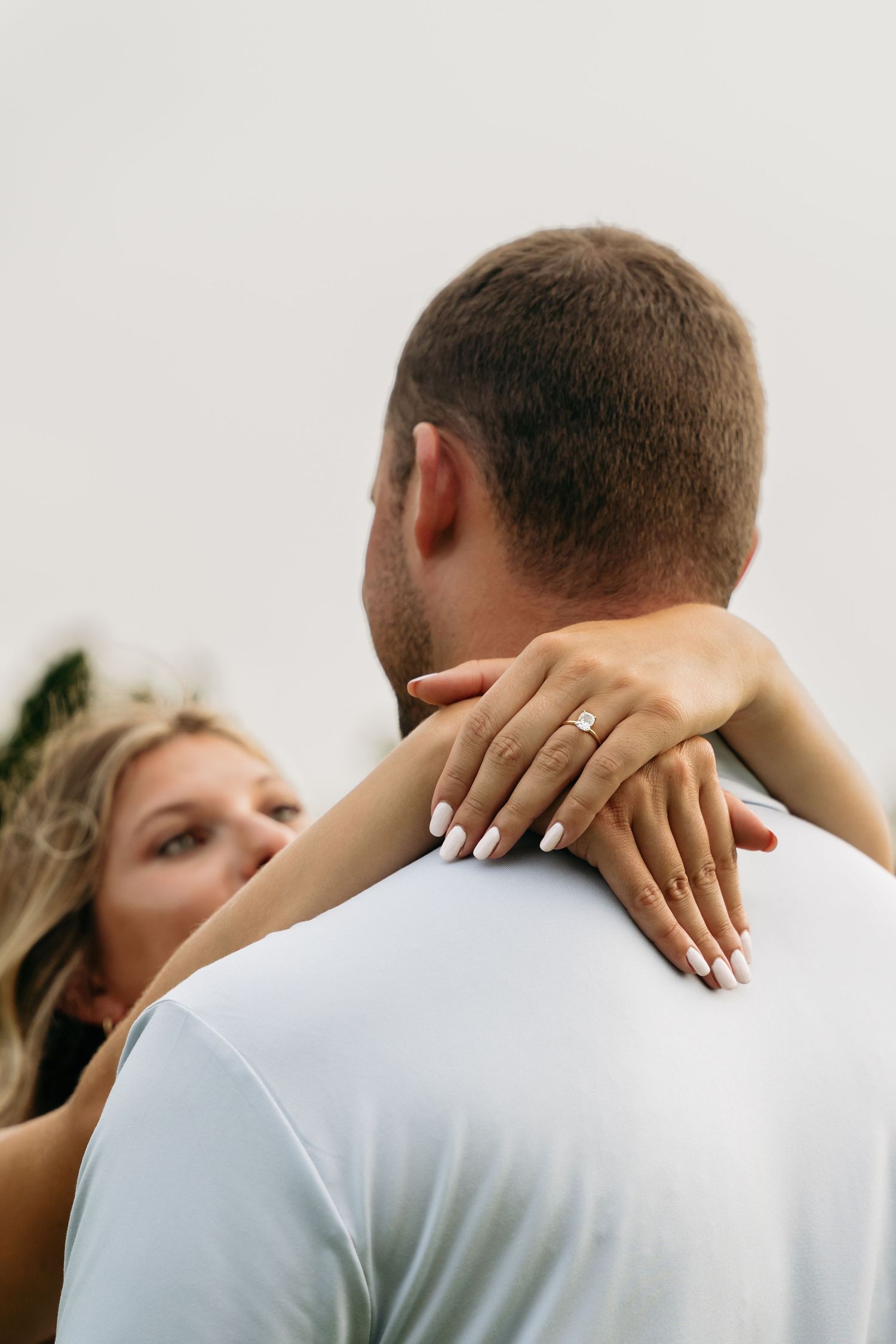 A series of intimate wedding photos showing a couple embracing in white attire against a light background.