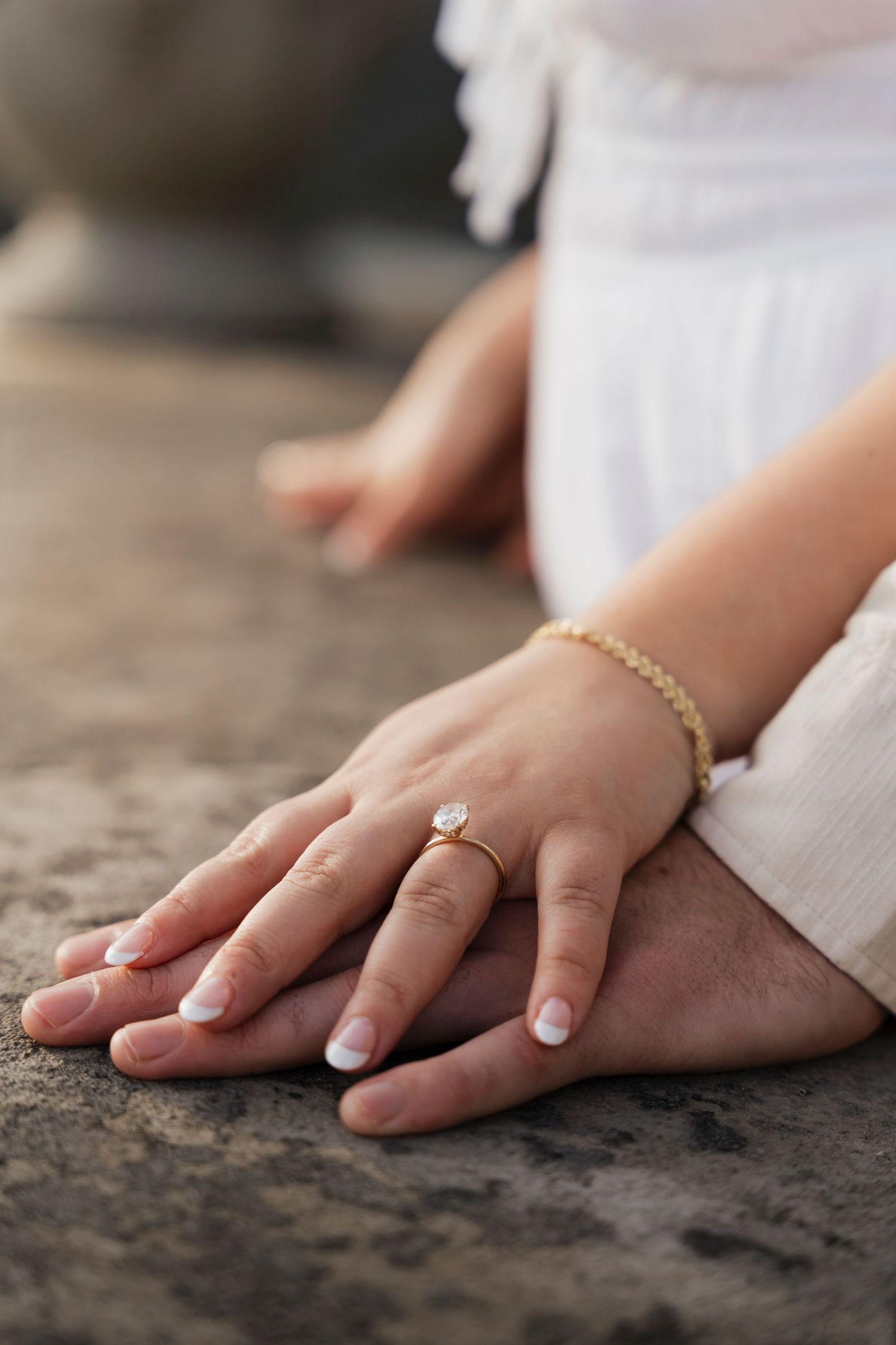 Close-up of engagement ring with historic Mount Assisi Gardens blurred in background