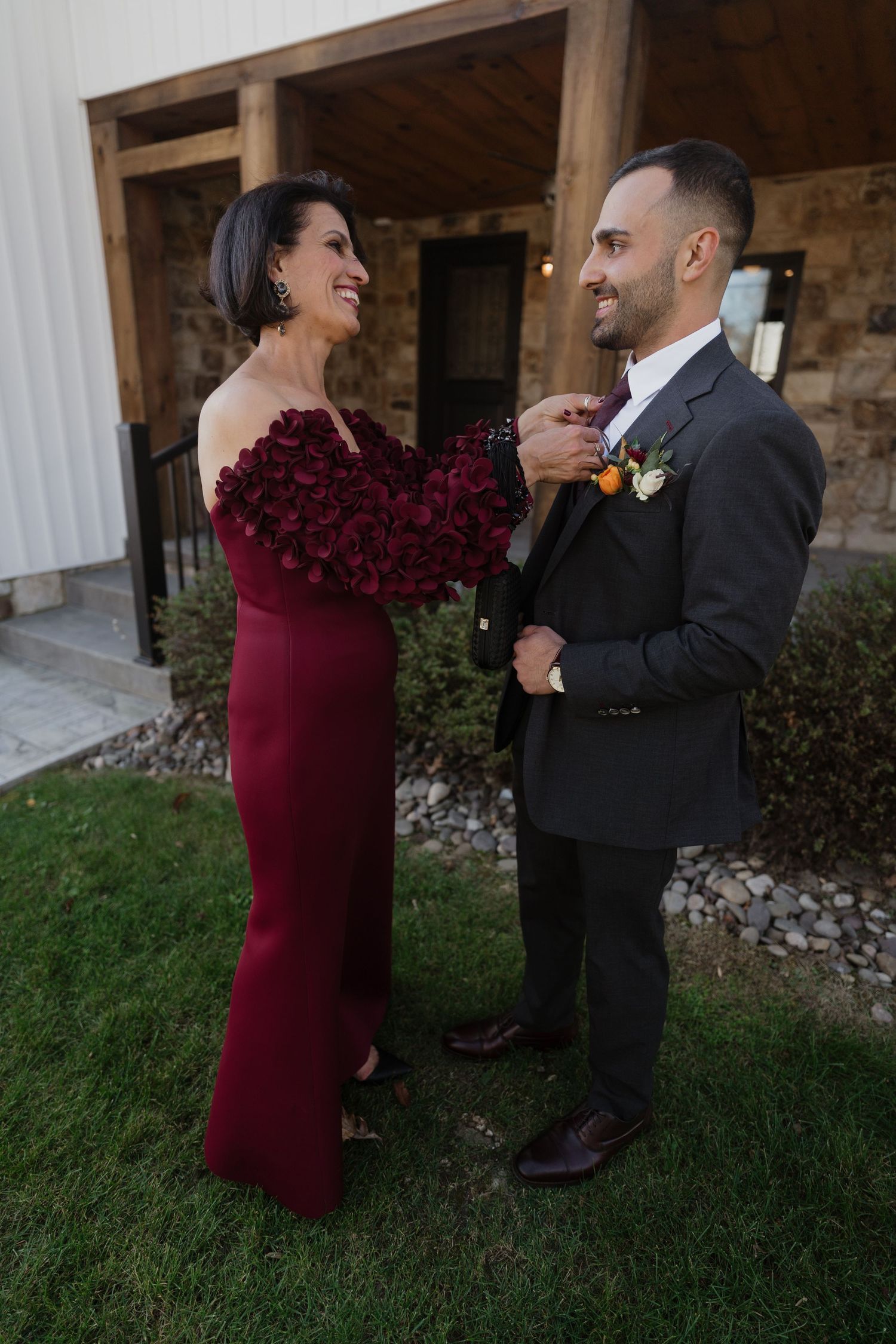 Wedding couple shares playful moments outside a rustic stone building.