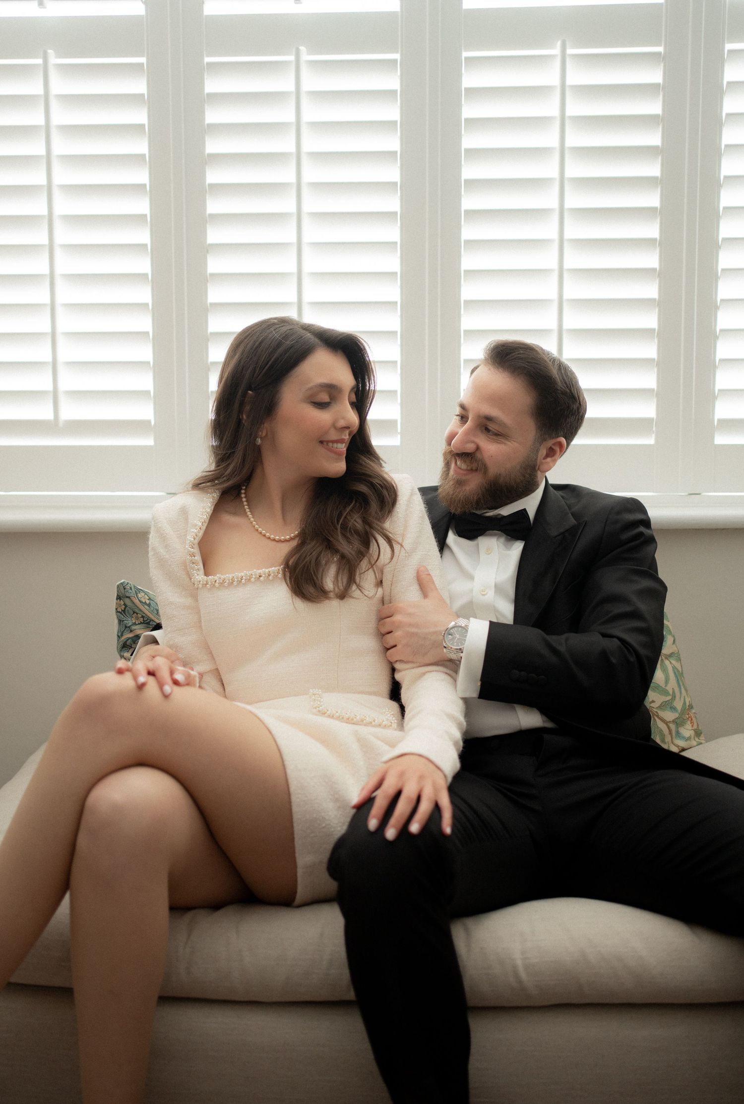 Romantic couple sharing intimate moments on a beige couch in sequence of candid photographs.
