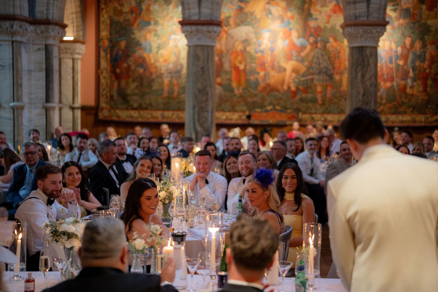 Elegant banquet hall with ornate wall murals and tables set for a formal dinner event.