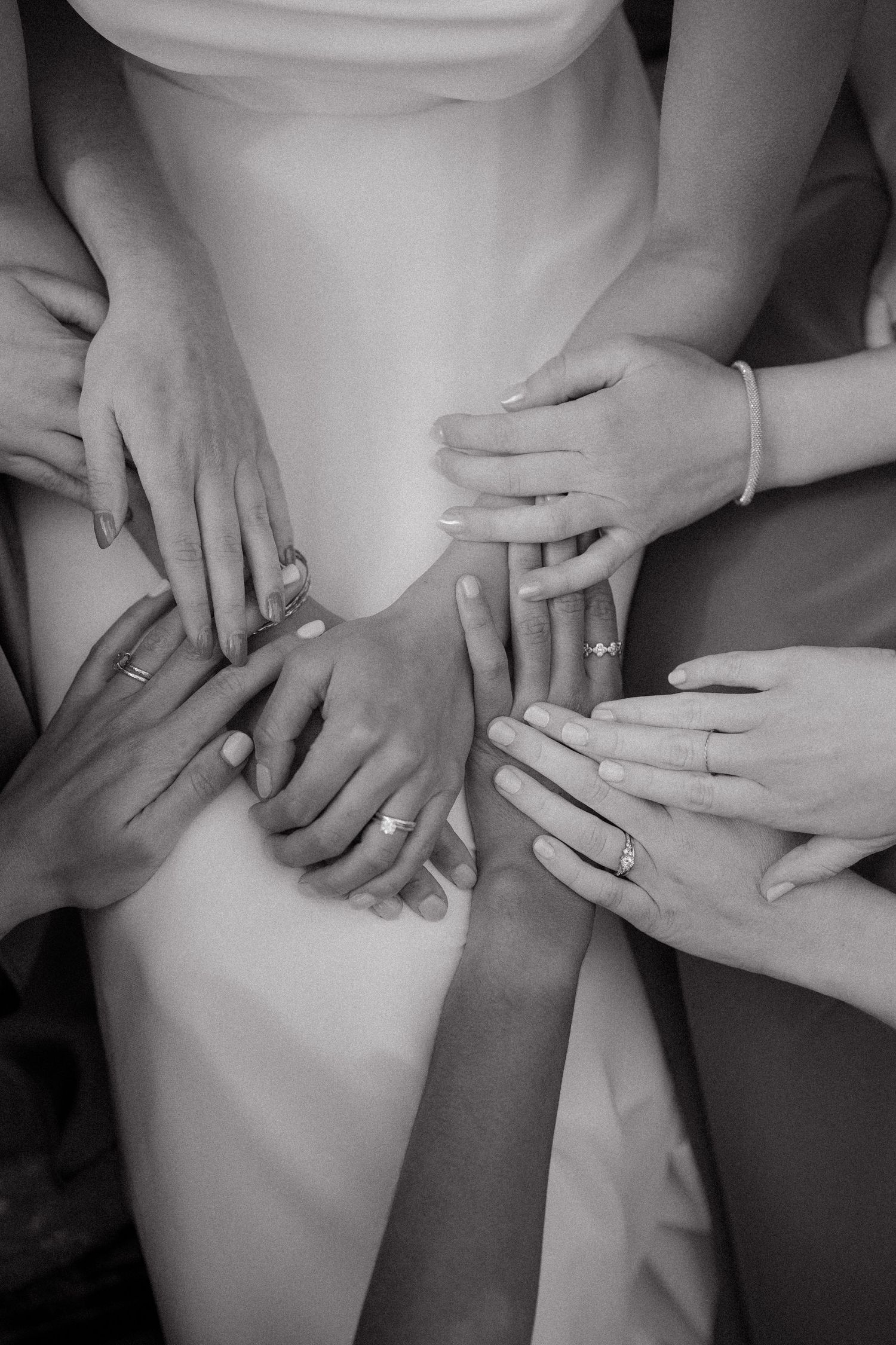 Close-up shots of hands showing wedding rings in black and white photography.