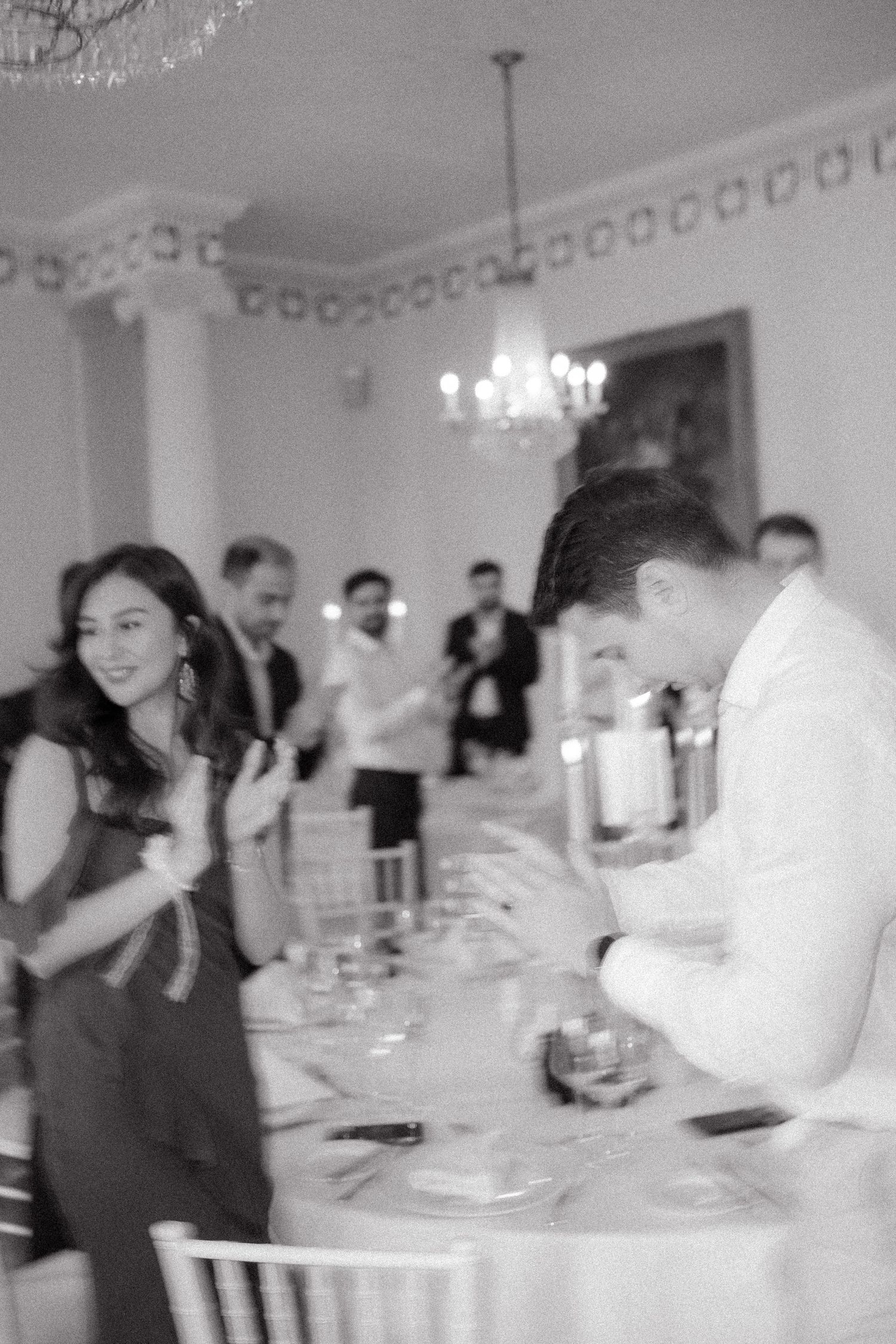 Wedding reception celebration with guests dining at elegantly set tables.