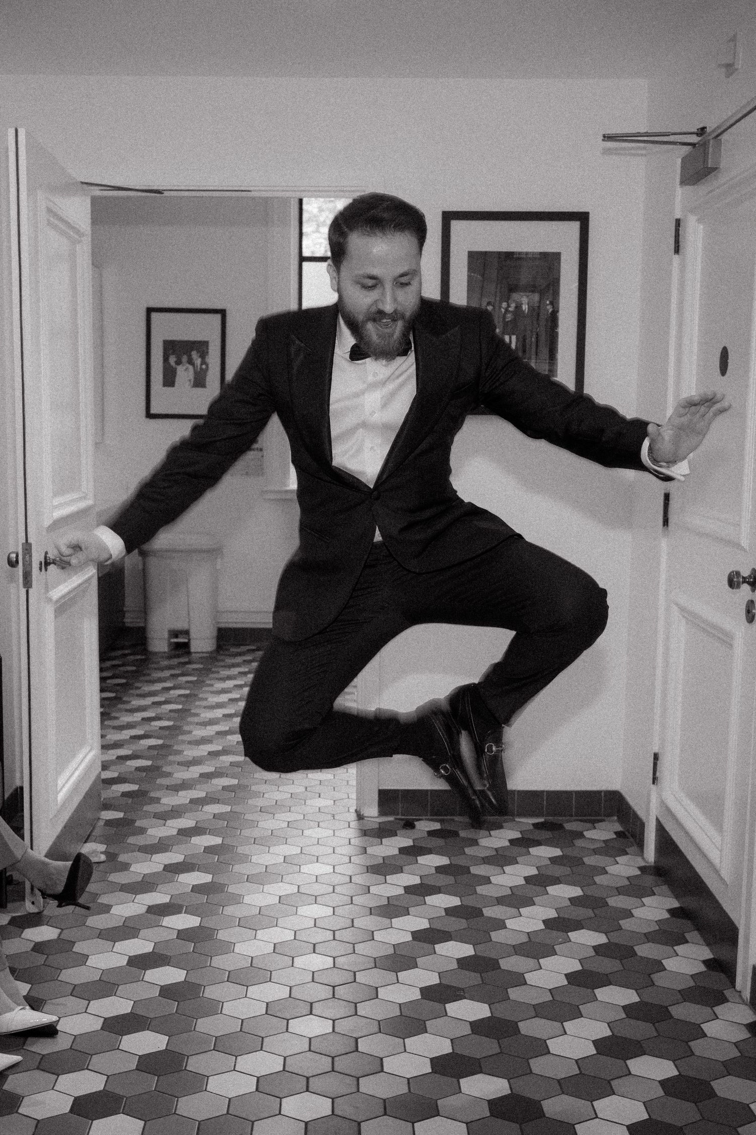 Series of photos showing someone in a suit falling on a black and white tiled floor.
