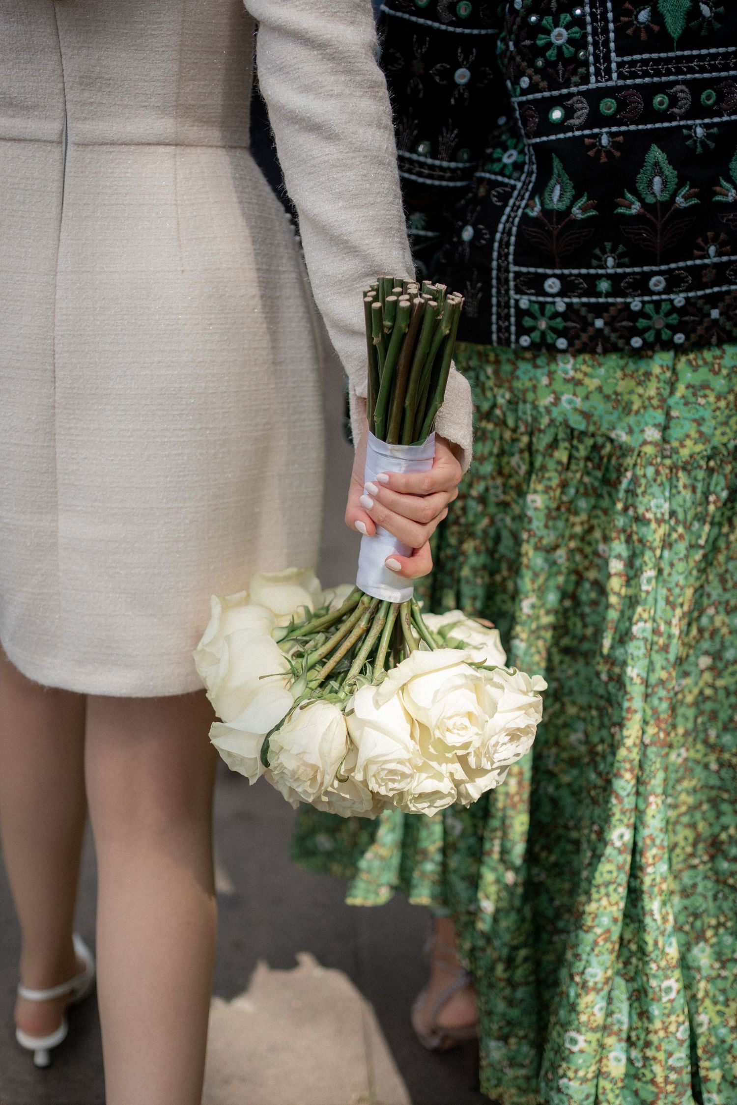White rose wedding bouquet held against a dark patterned backdrop in multiple detail shots.