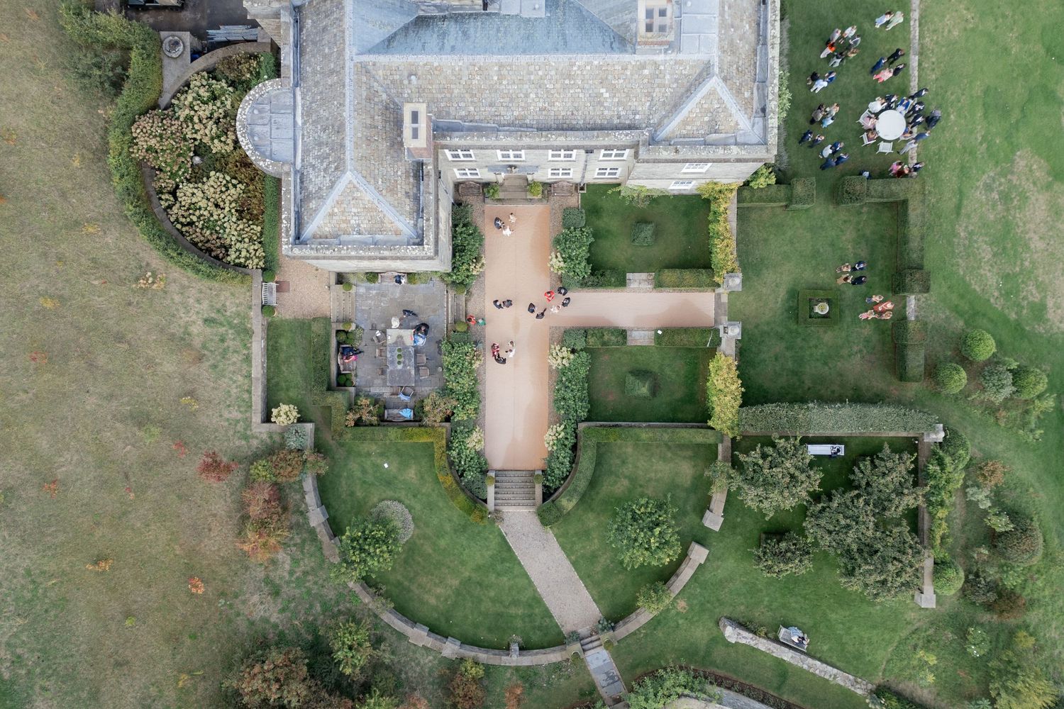 Aerial view of a large estate property with multiple buildings and landscaped gardens surrounded by green fields.