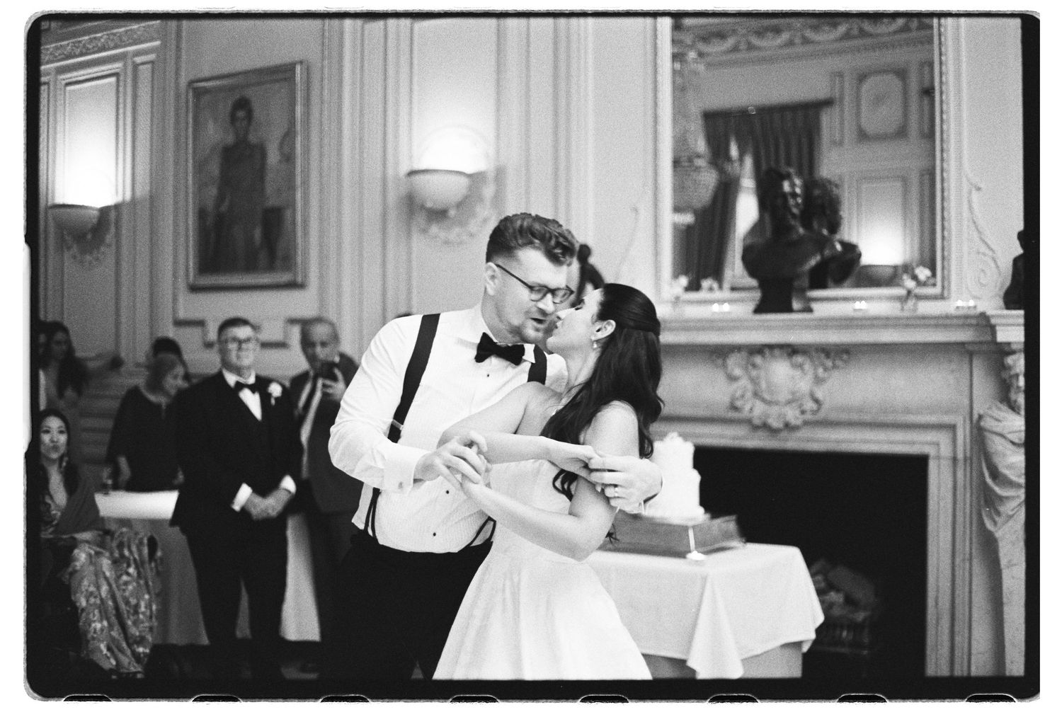Black and white photo of a couple sharing their first dance at an elegant wedding reception venue.