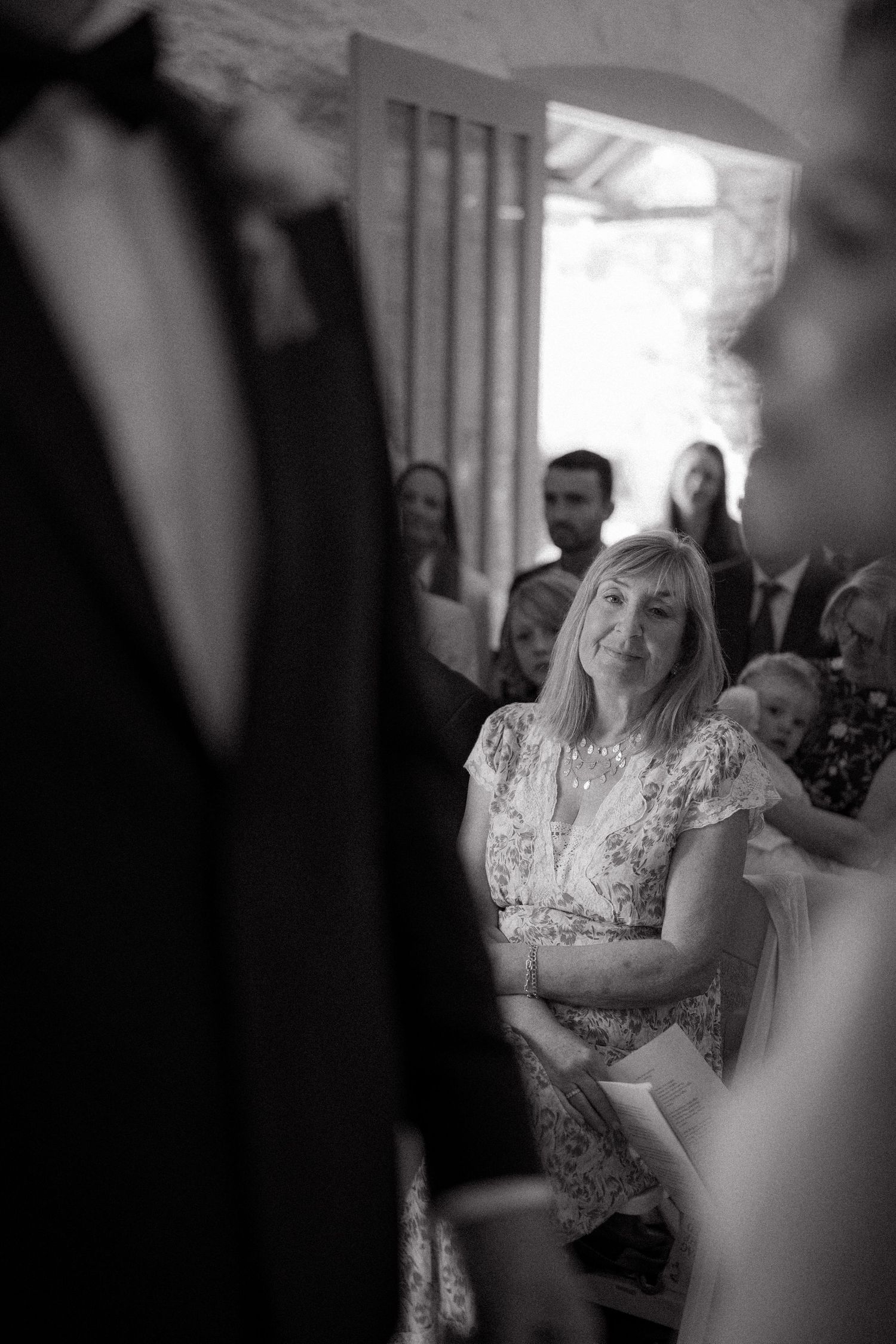 Wedding guests watch emotionally during a ceremony in black and white.