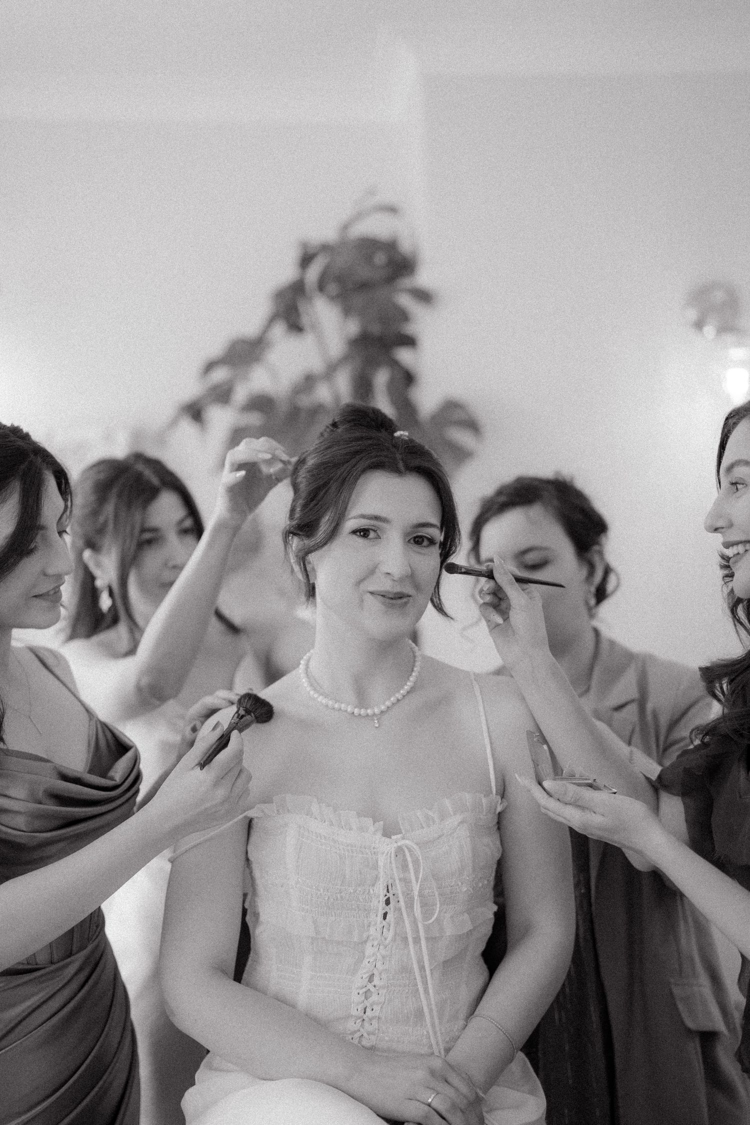 Wedding party members sharing joyful laughter in a bright indoor setting.