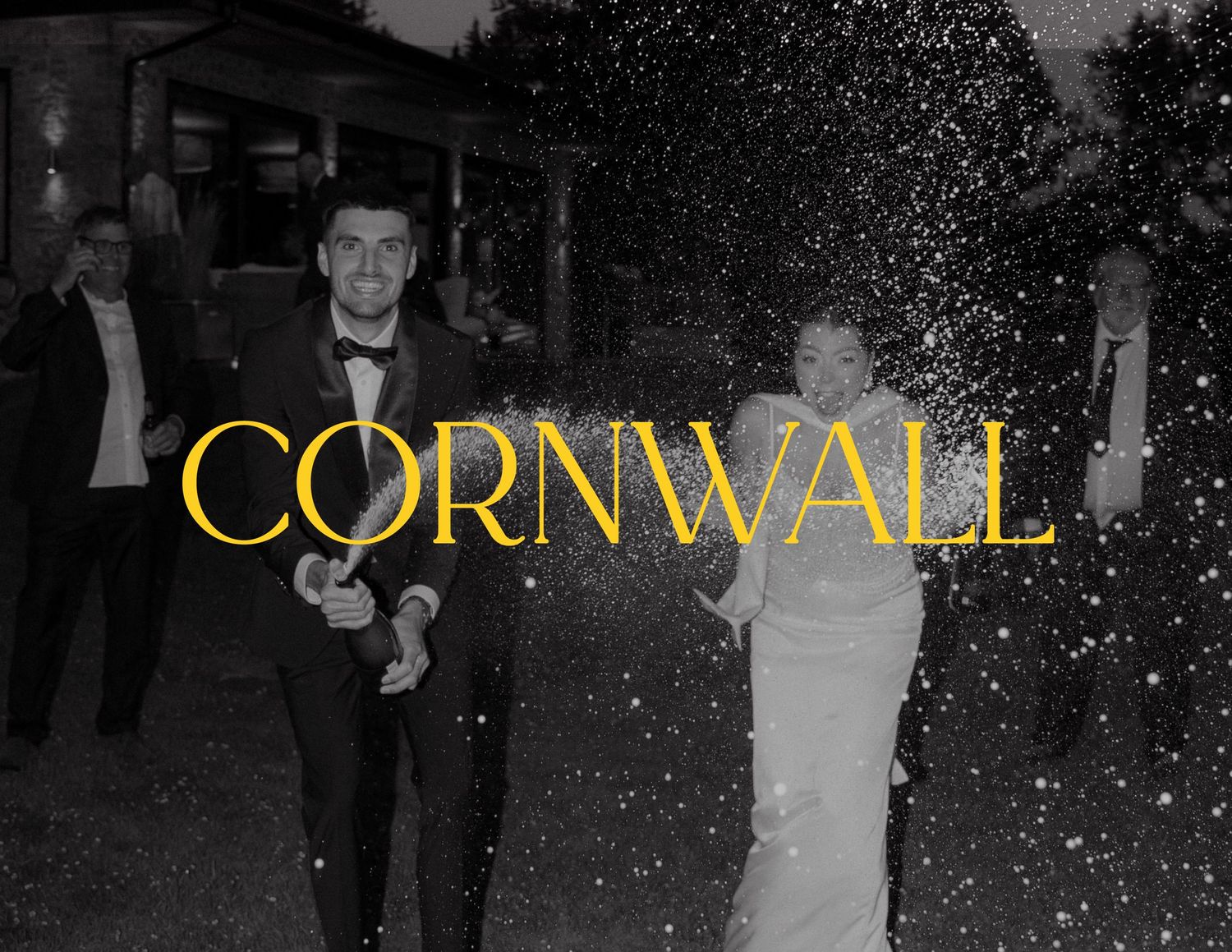 Black and white photo with golden 'CORNWALL' text overlay showing celebration with sparklers.