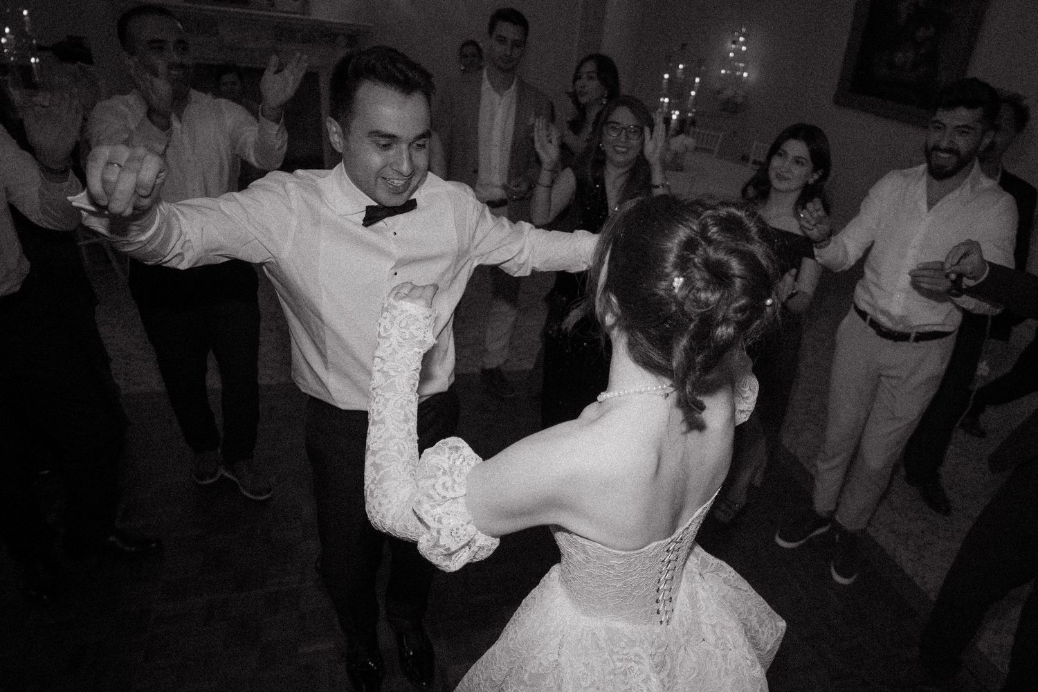 Wedding guests dancing and celebrating on the dance floor during reception.