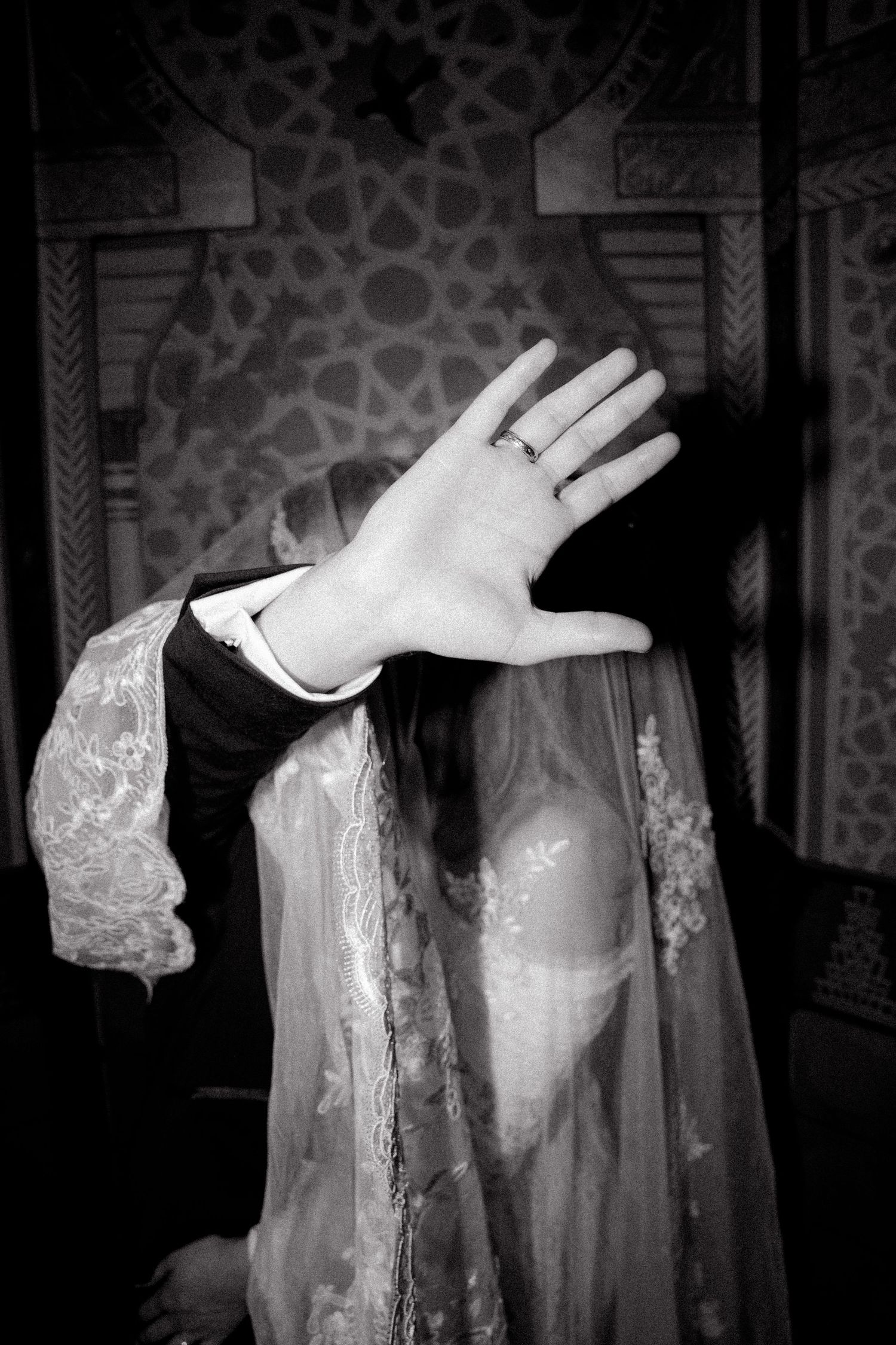 A series of black and white photos showing hands raised against a dark background with lace sleeves.