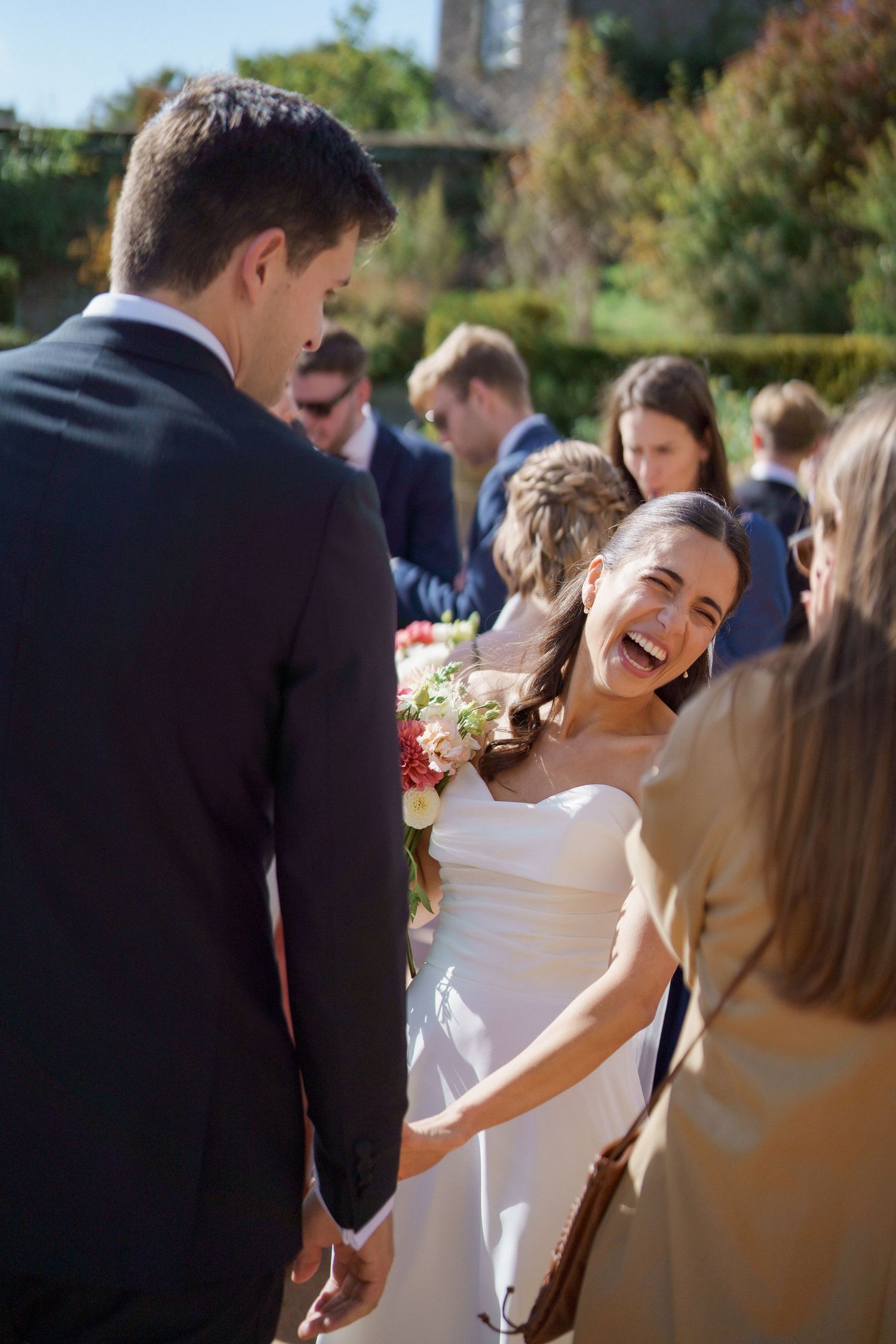 Wedding celebration outdoors with guests gathered in formal attire.