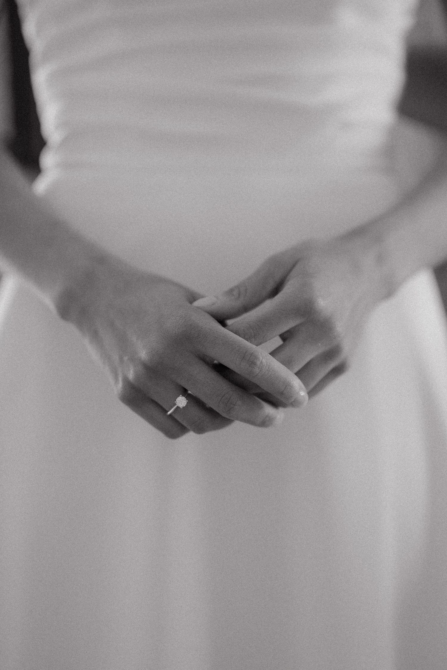 Close-up series of hands wearing wedding rings in soft black and white photography.