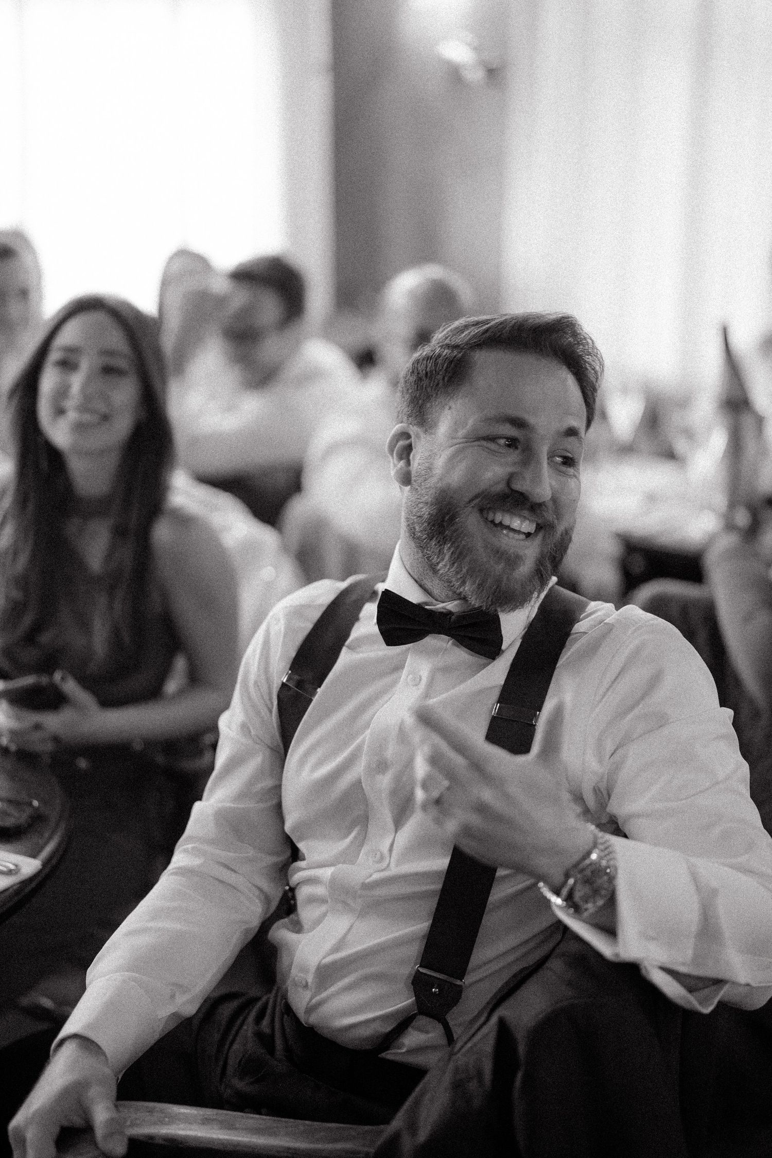 Black and white candid shots of wedding guests laughing during reception celebrations.