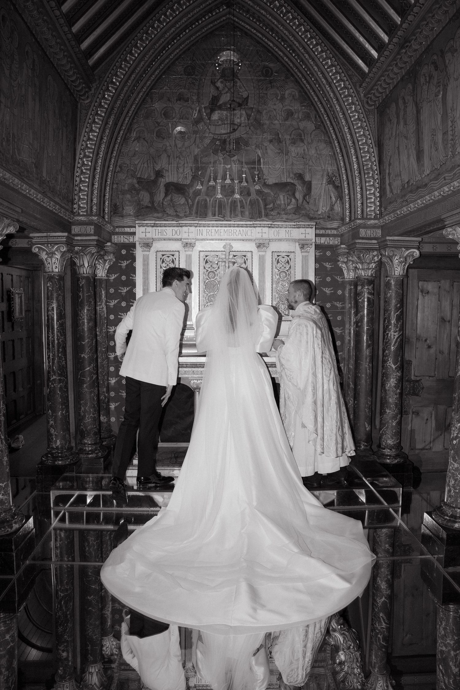 Wedding dresses displayed in a dimly lit Gothic church corridor.