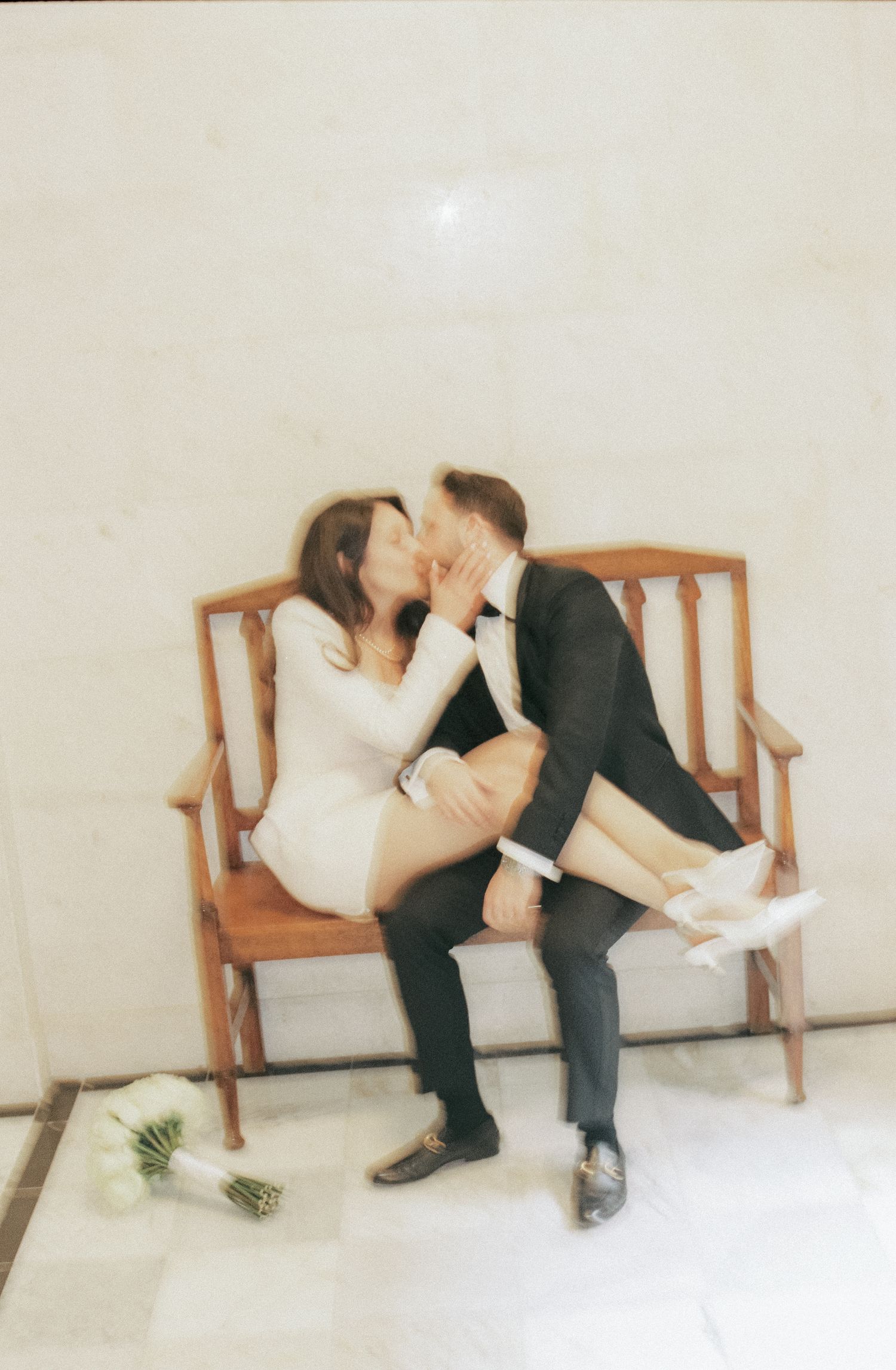 A romantic sequence shows a couple on a wooden bench sharing an intimate moment with a bouquet nearby.