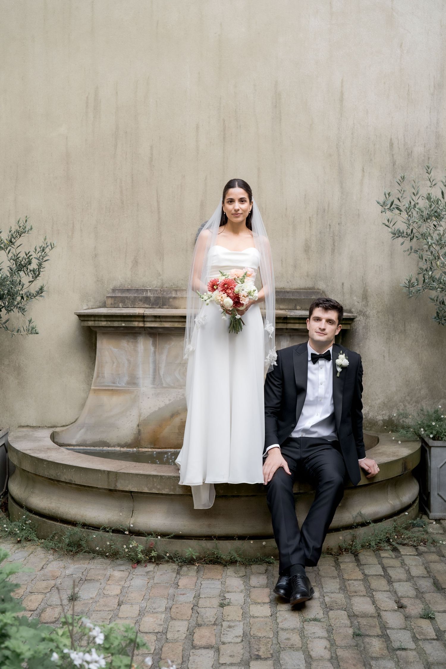 A series of artistic wedding photos showing a couple posing against a textured concrete wall and brick path.