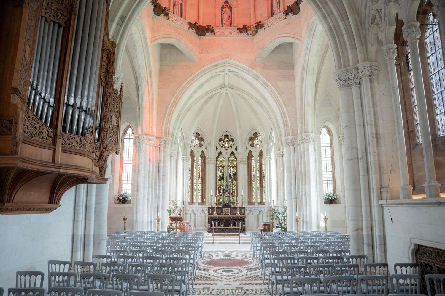 Interior panorama of a gothic cathedral with vaulted ceilings and warm lighting.