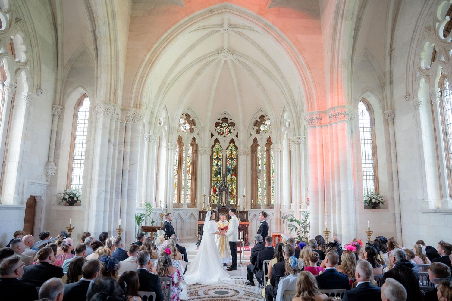 Wedding ceremony in a grand Gothic cathedral with ornate architectural details and soft lighting.