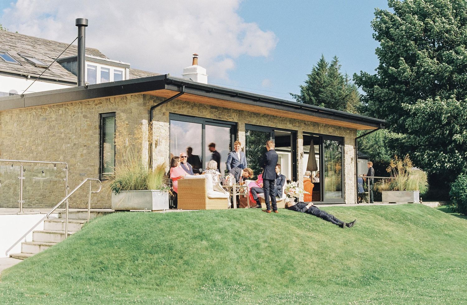 Panoramic view of a rustic wedding venue with stone buildings and grassy hills.