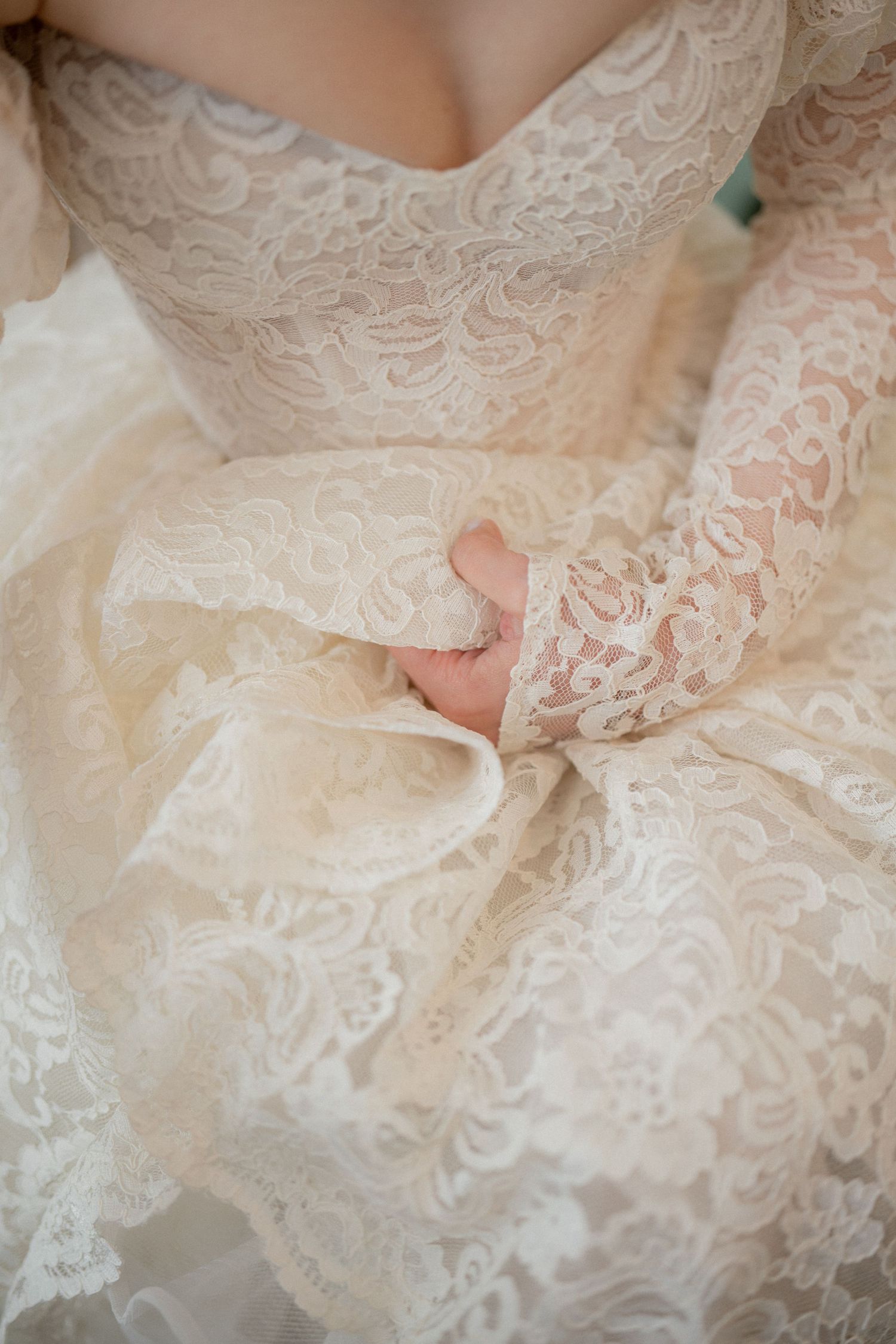 Detailed views of delicate white lace patterns on a wedding dress.