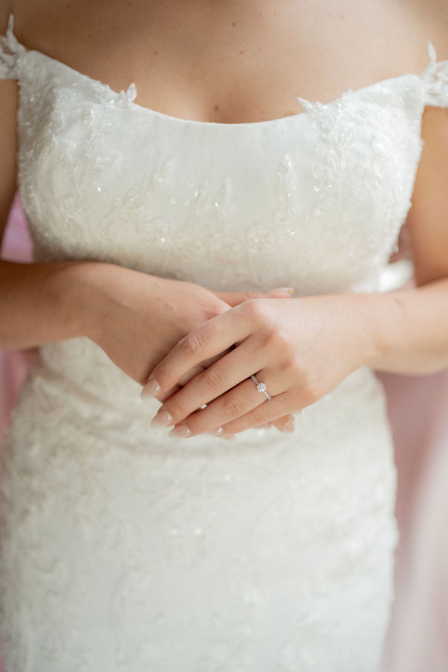 Close-up details of a white lace wedding dress with delicate beading and embellishments.