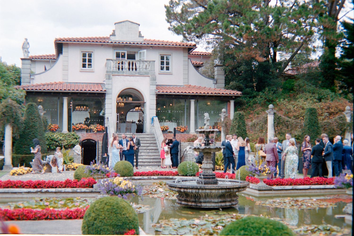 A scenic collage of a Mediterranean-style villa with red flowers and fountains in its manicured gardens.