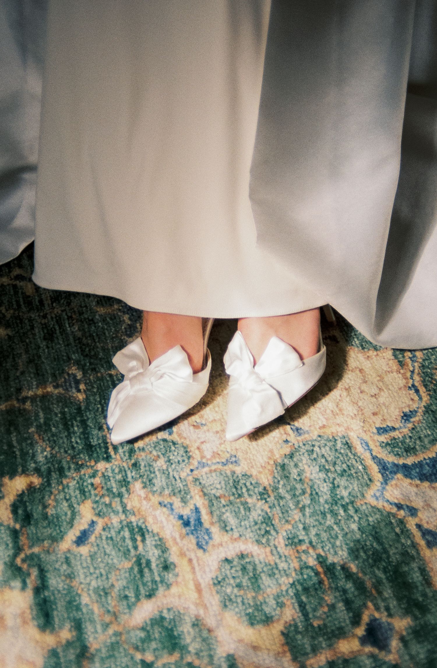 White bridal shoes on a vintage turquoise patterned carpet shown in a sequence of three similar views.