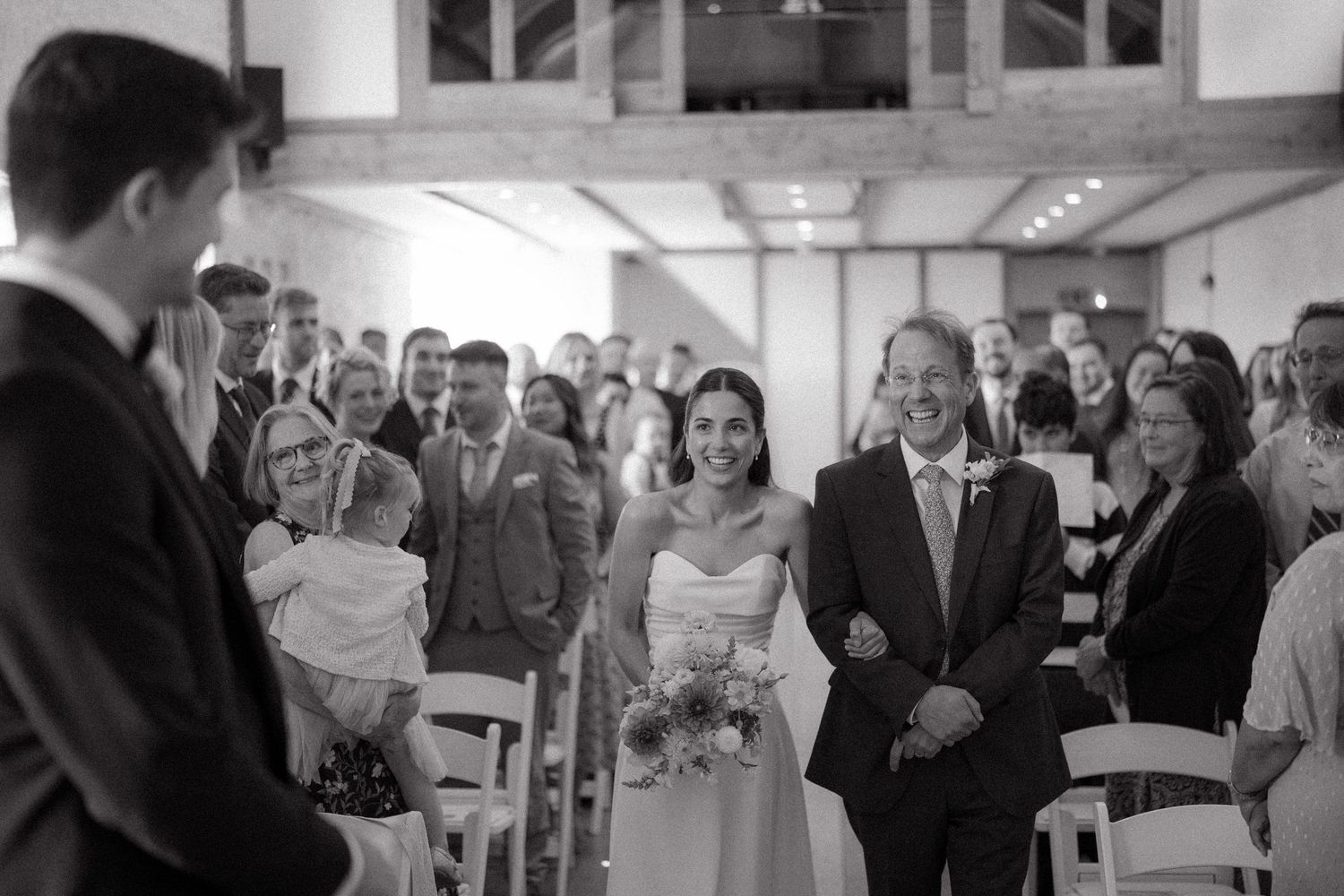 Black and white photo montage showing wedding guests mingling and celebrating at a reception venue.