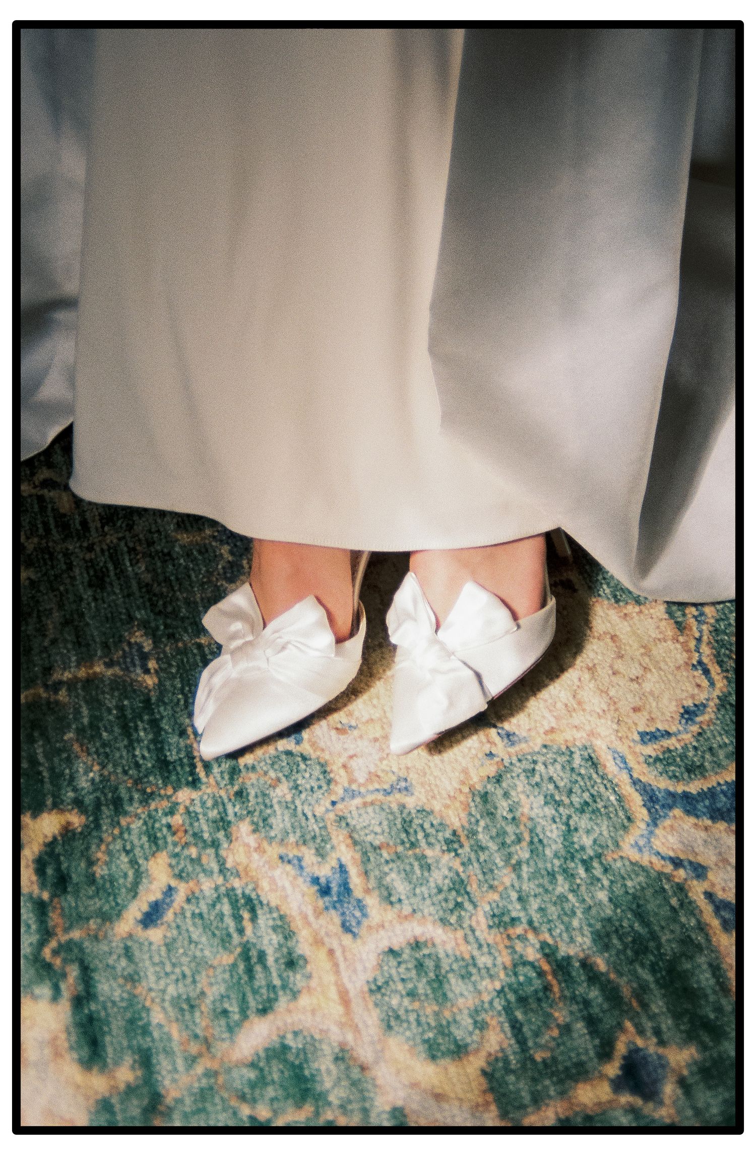 Close-up view of white bridal shoes on a distressed turquoise floor creating an elegant contrast.