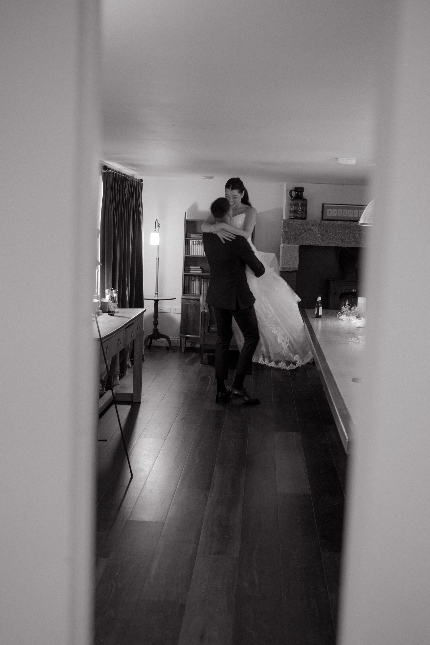 Black and white photo of a couple dancing in an intimate indoor setting.