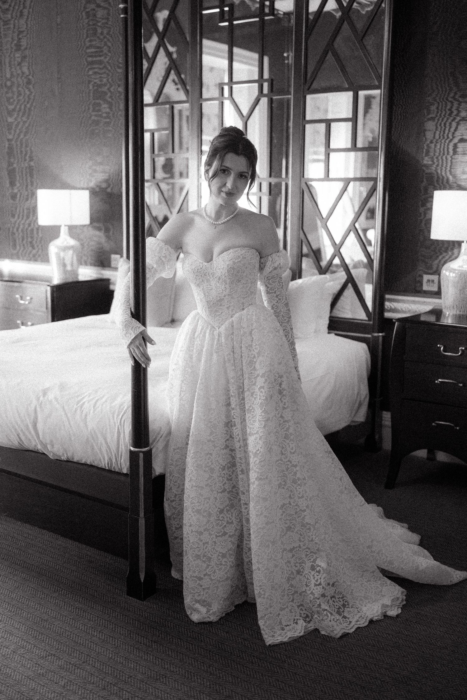 Wedding dress detail shot showing intricate lace pattern in black and white.