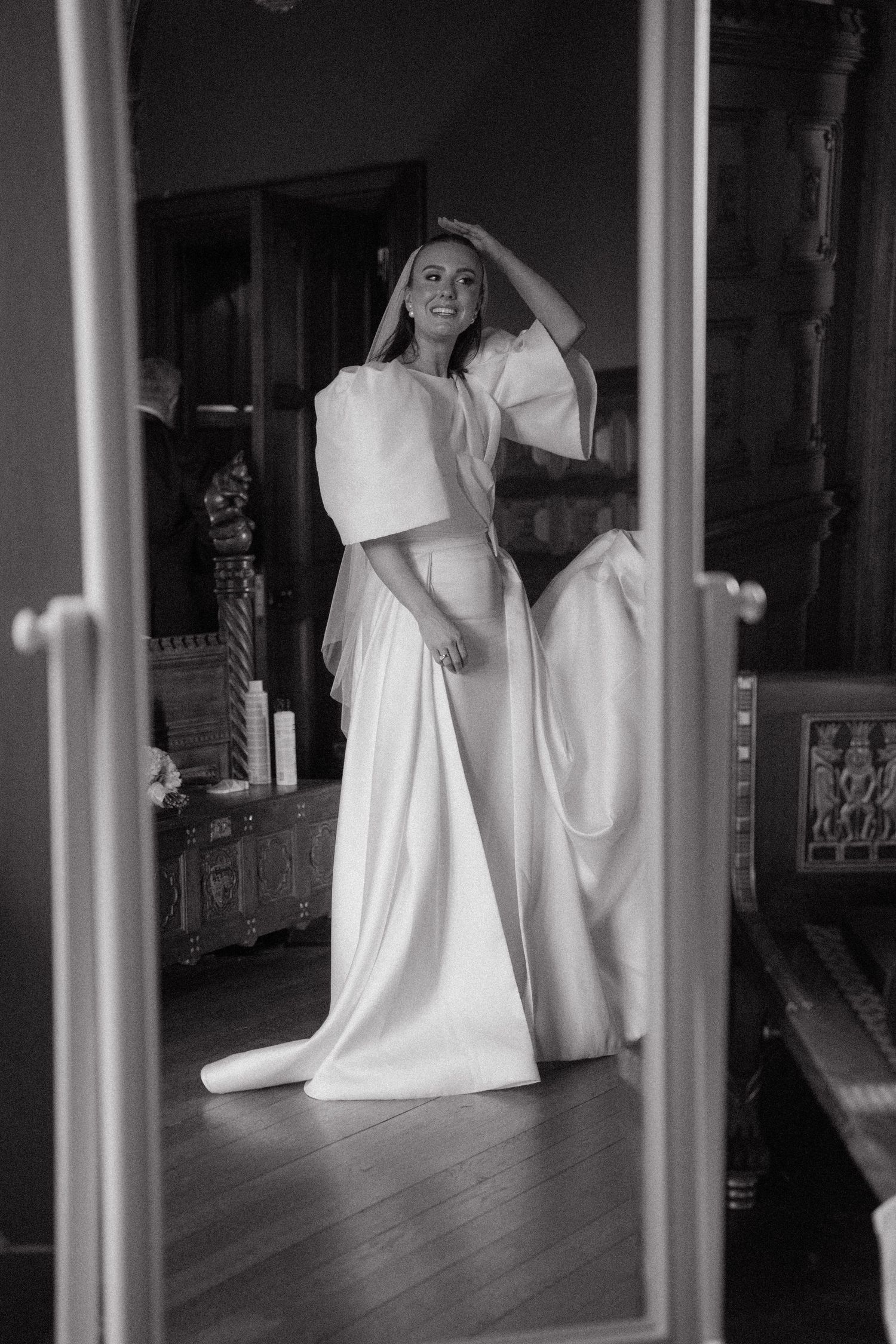 Artistic black and white reflection of wedding preparations through mirrored surfaces.